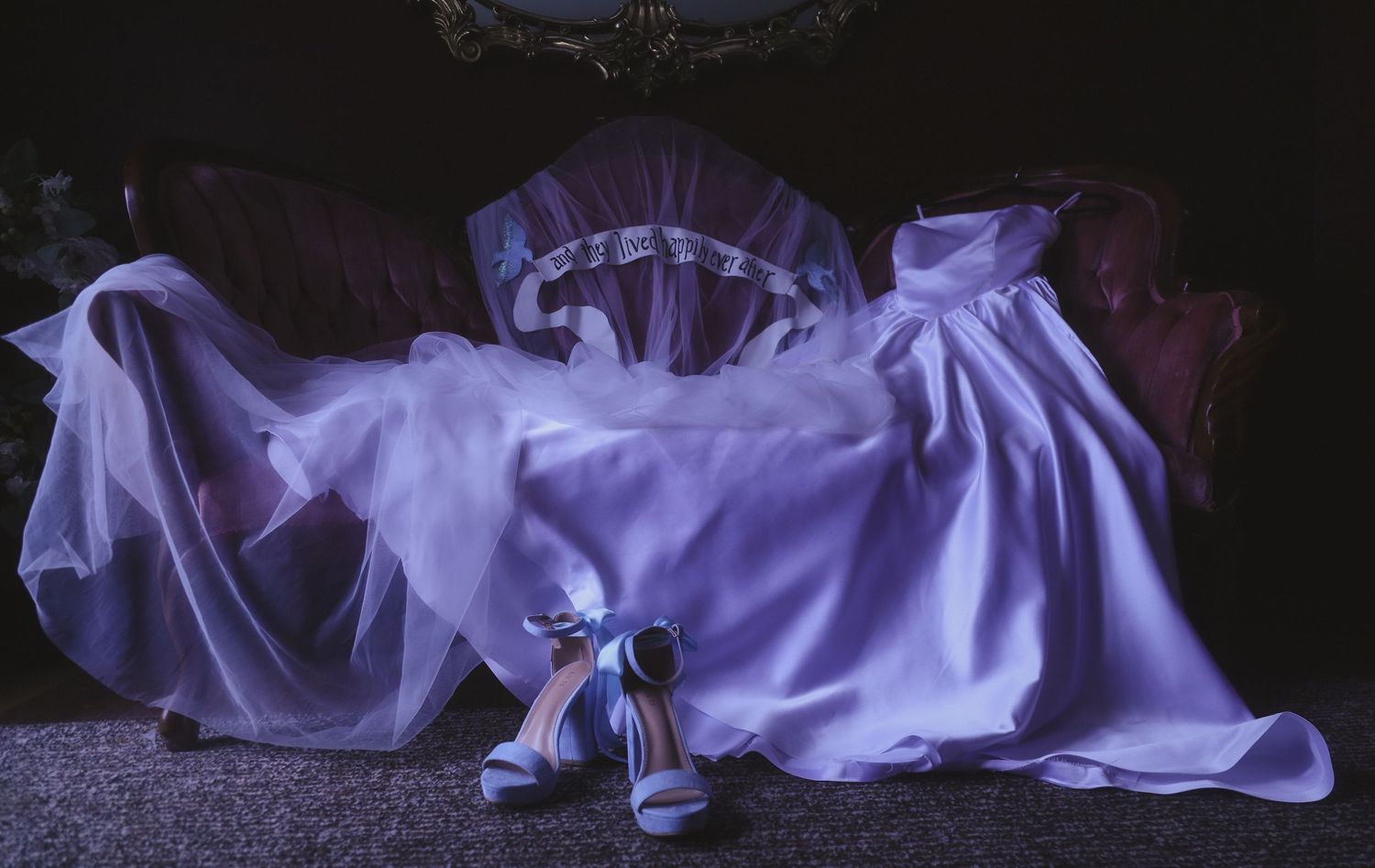 Ethereal purple fabric flows dramatically across a dark surface creating an artistic sculptural form in low light.