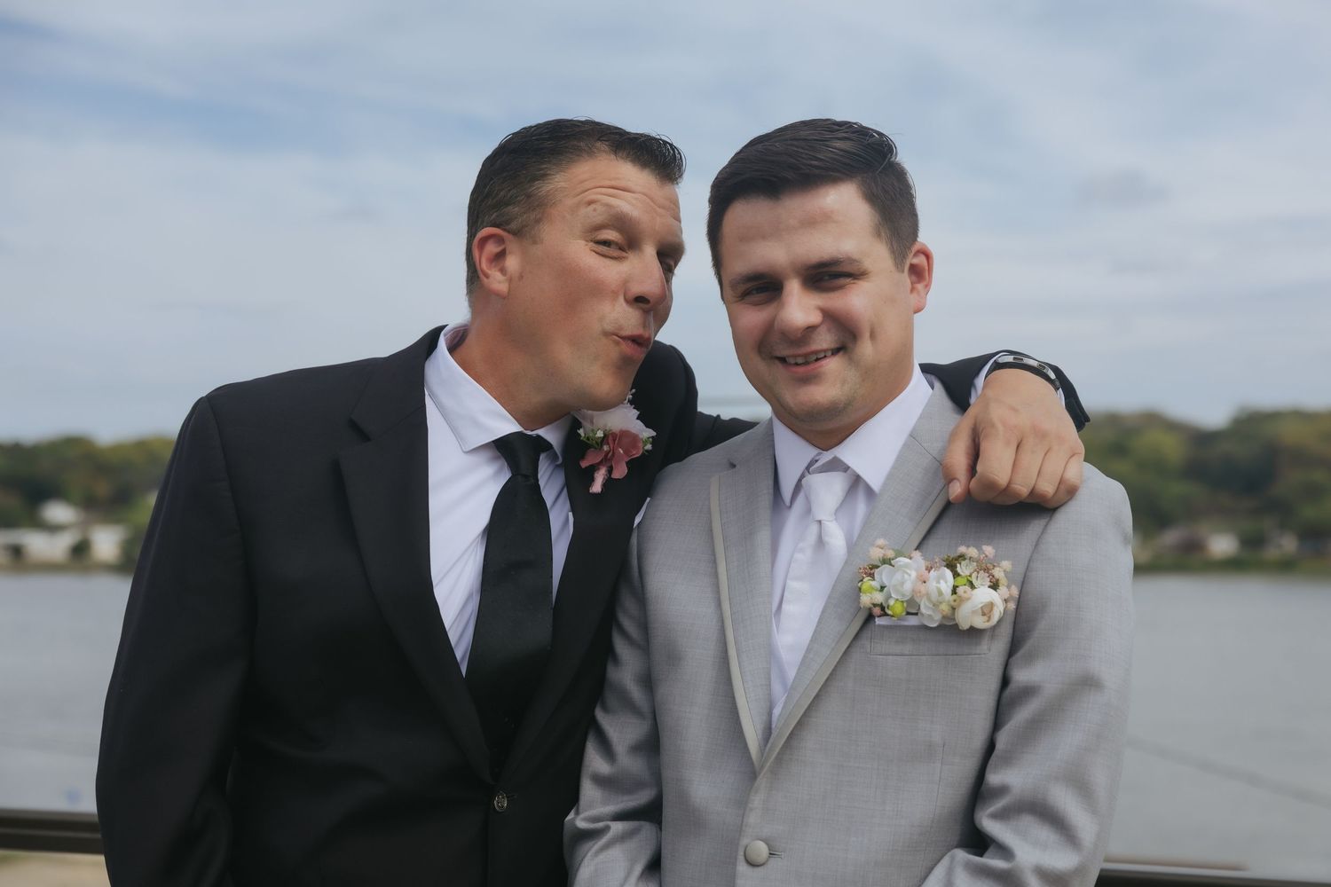 Two people in wedding attire share tender moments by a waterfront in multiple candid shots.