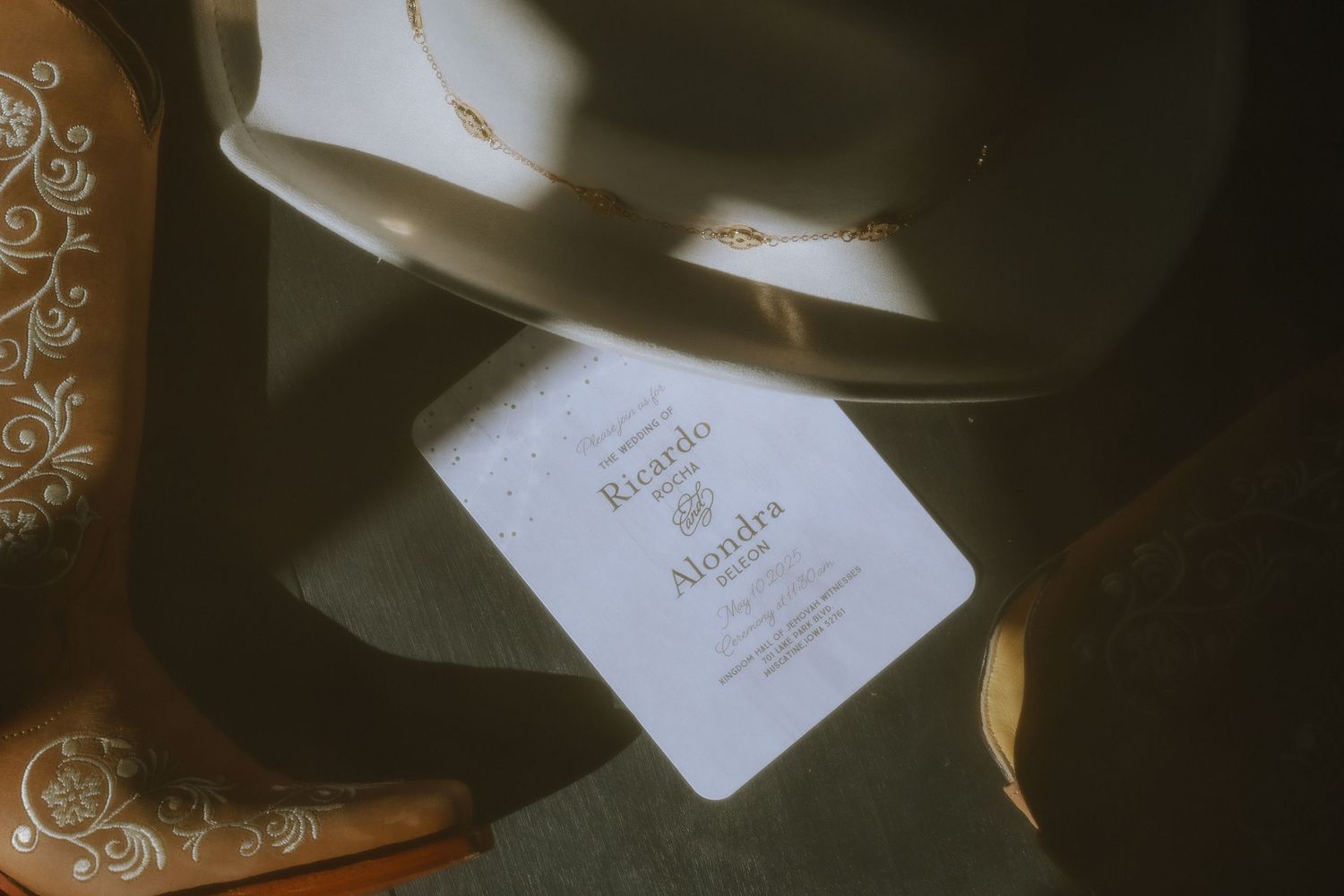A white paper card with elegant text lies among soft shadows and textured fabric in warm lighting.