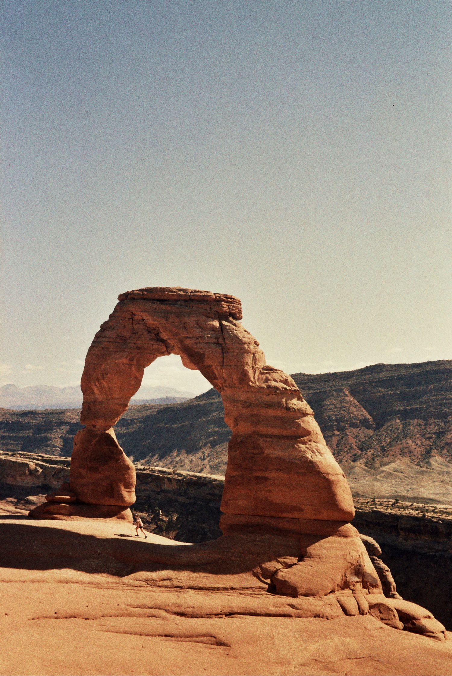 Iconic Delicate Arch stands against a blue sky in Arches National Park, Utah, showcasing its natural sandstone formation.