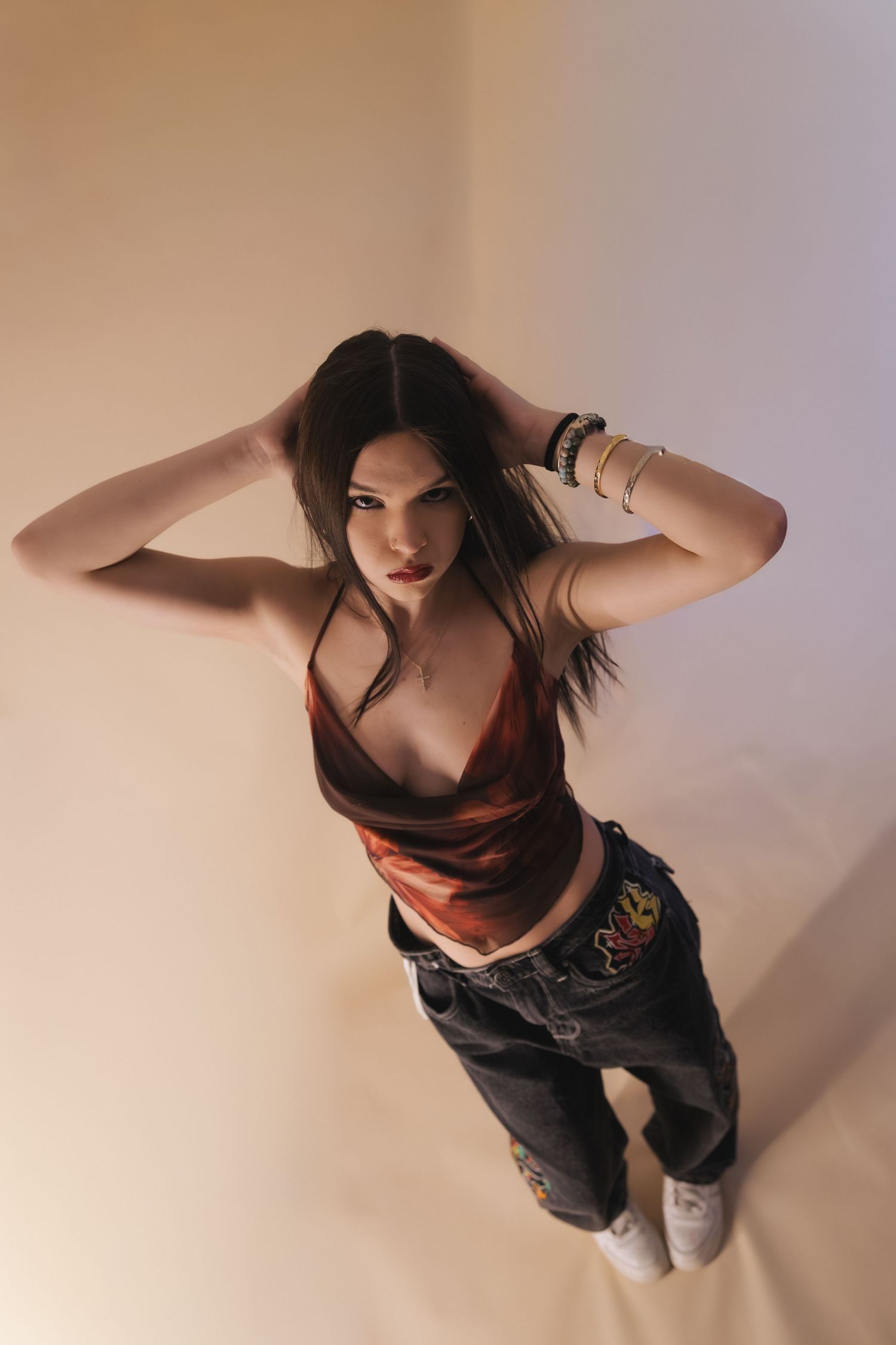 A sequence of fashion photos showing a person in dark clothing posing against a light colored wall.