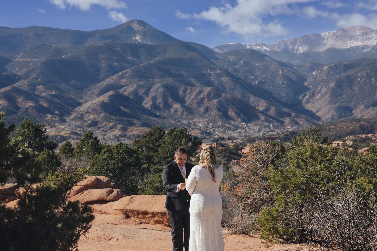 Couple exchanging vows at Garden of the Gods with Pikes Peak mountain backdrop in Colorado Springs.