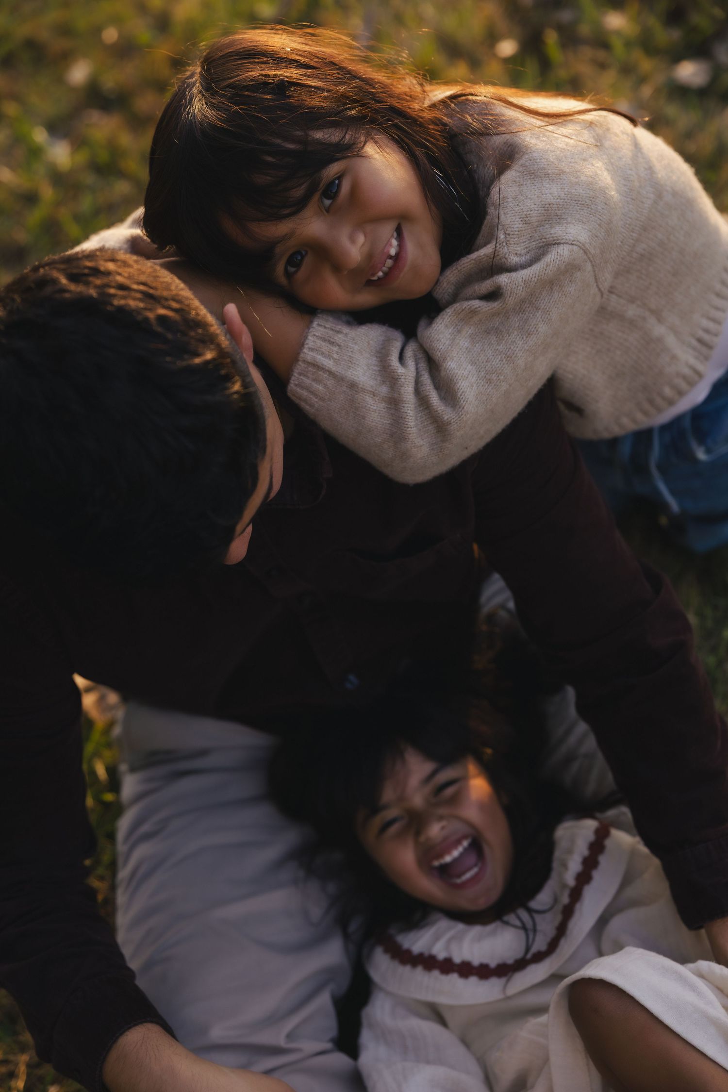A sequence of candid photos showing two people laughing and embracing while sitting together outdoors.