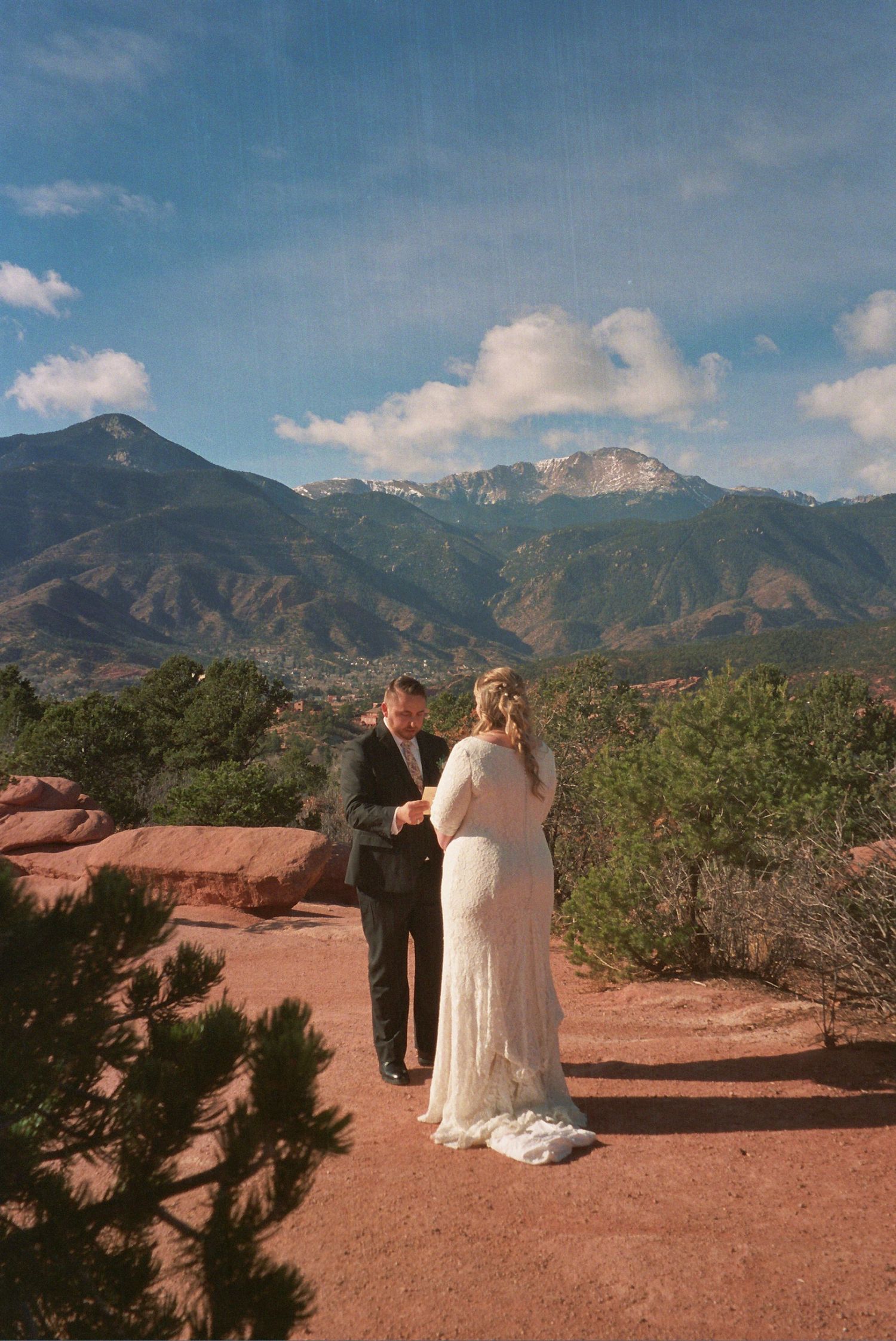 Couple exchanging vows outdoors at Garden of the Gods with Pikes Peak mountain backdrop in Colorado Springs.