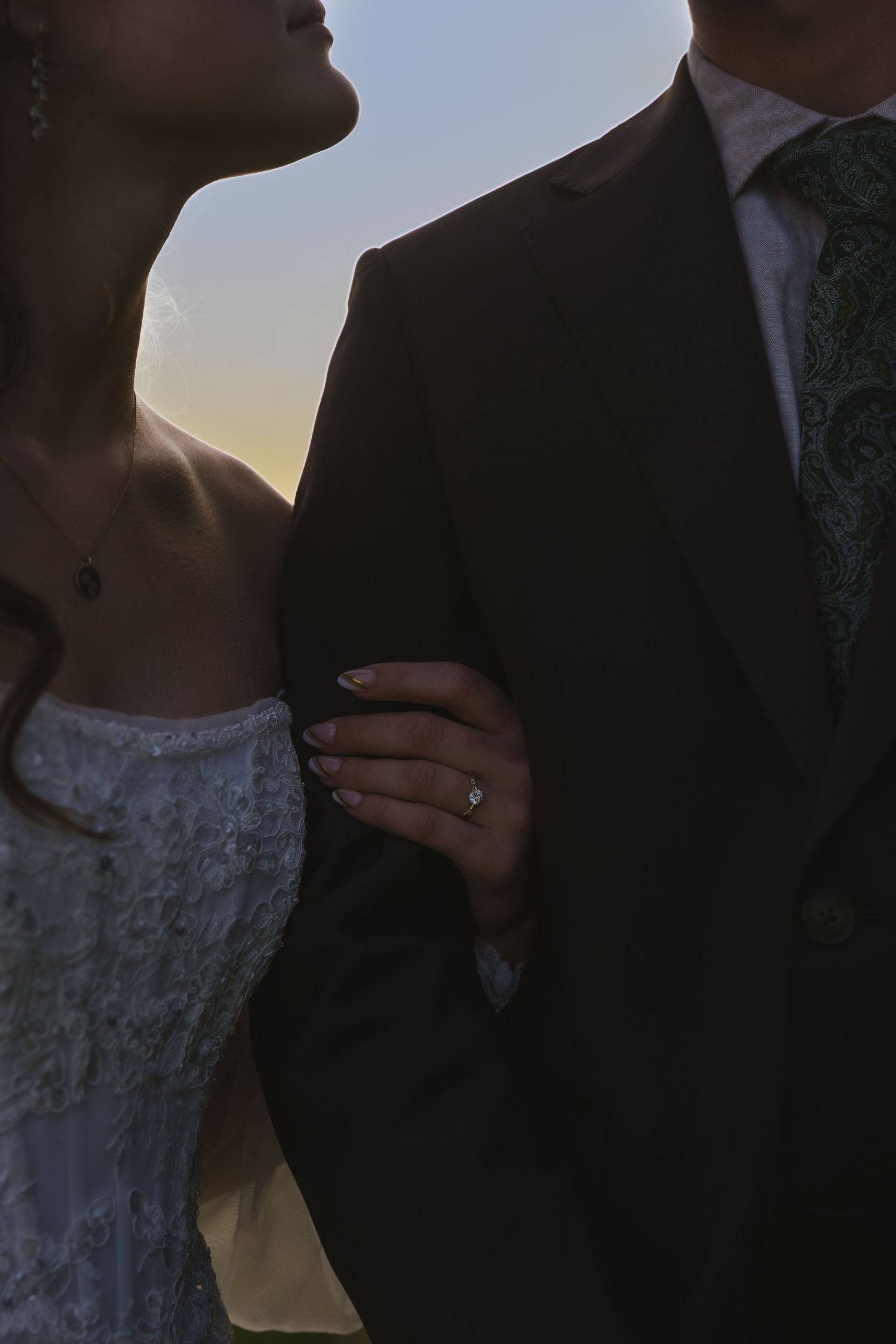 A romantic silhouette of a bride and groom embracing and kissing against a soft sunset background through multiple frames.