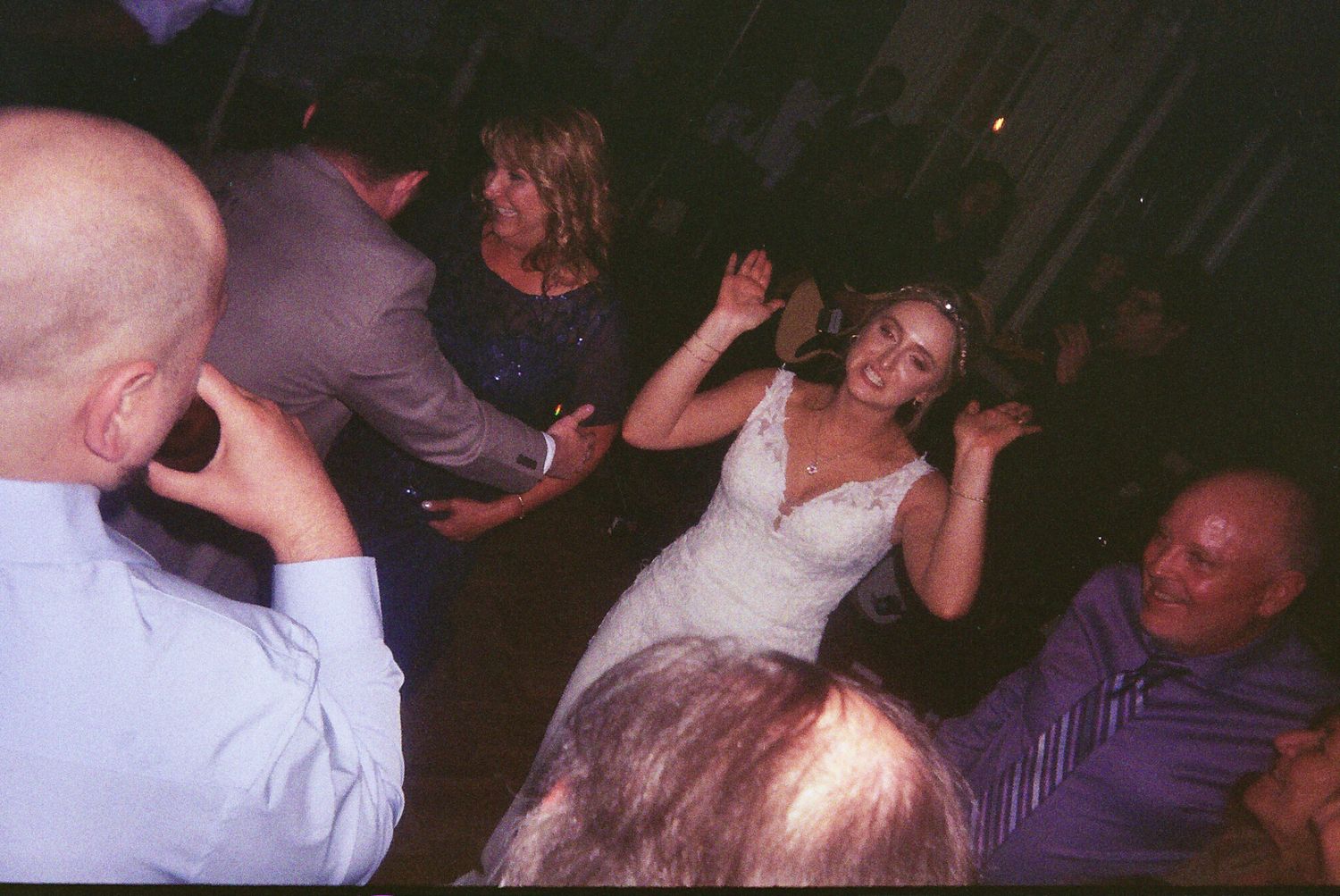 People enjoying themselves and dancing energetically at a dark nightclub during a party event.