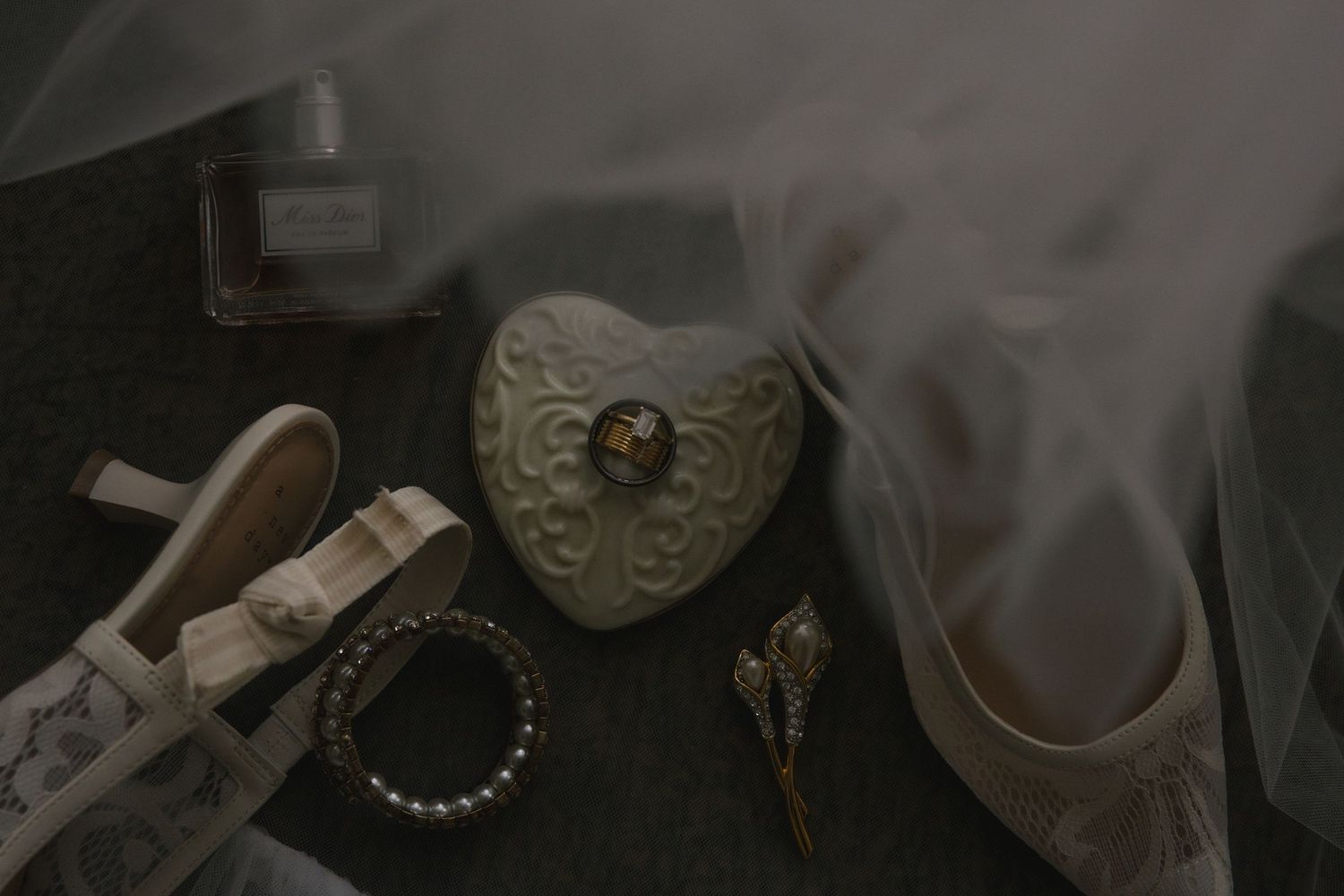 A collection of vintage items including a pearl necklace, ornate frames, and antique decorative objects in muted tones.