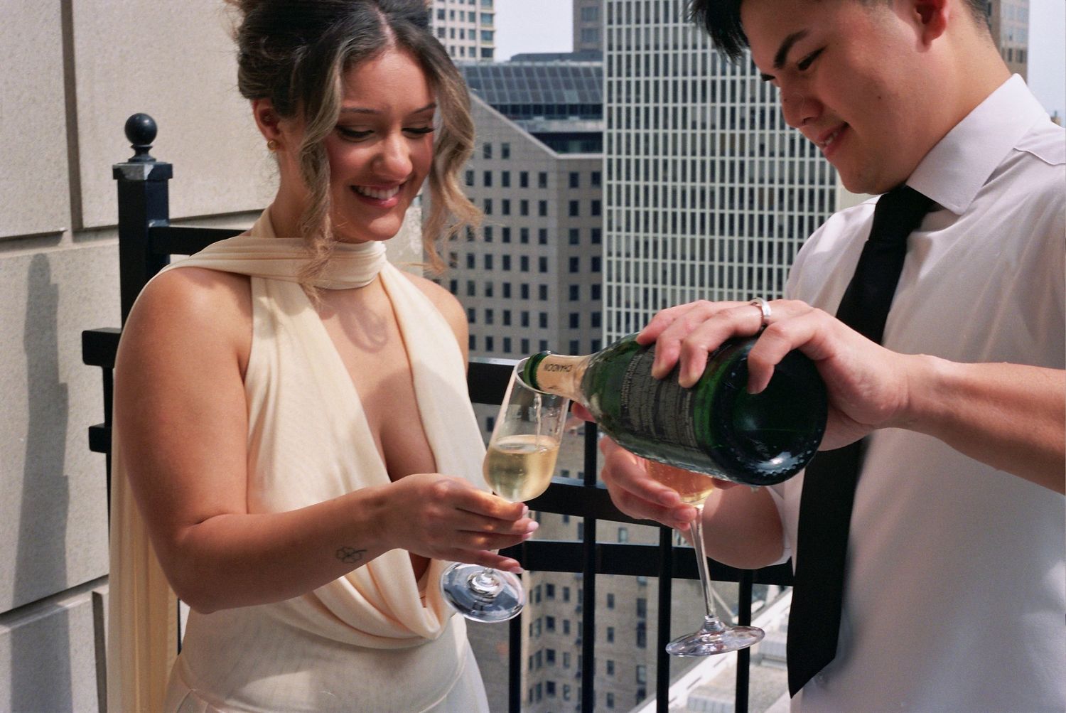 People enjoying small plates of food and drinks while mingling at an urban rooftop cocktail party.