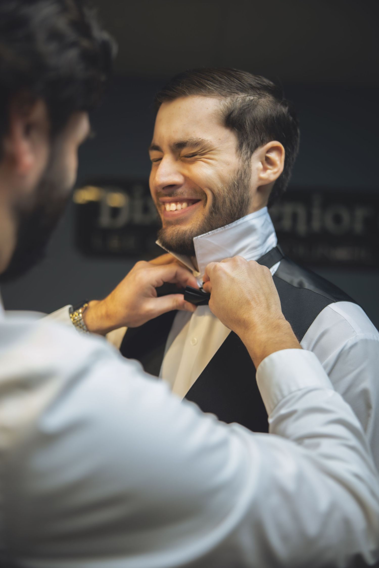 A candid moment of bow tie adjustment during wedding preparations.