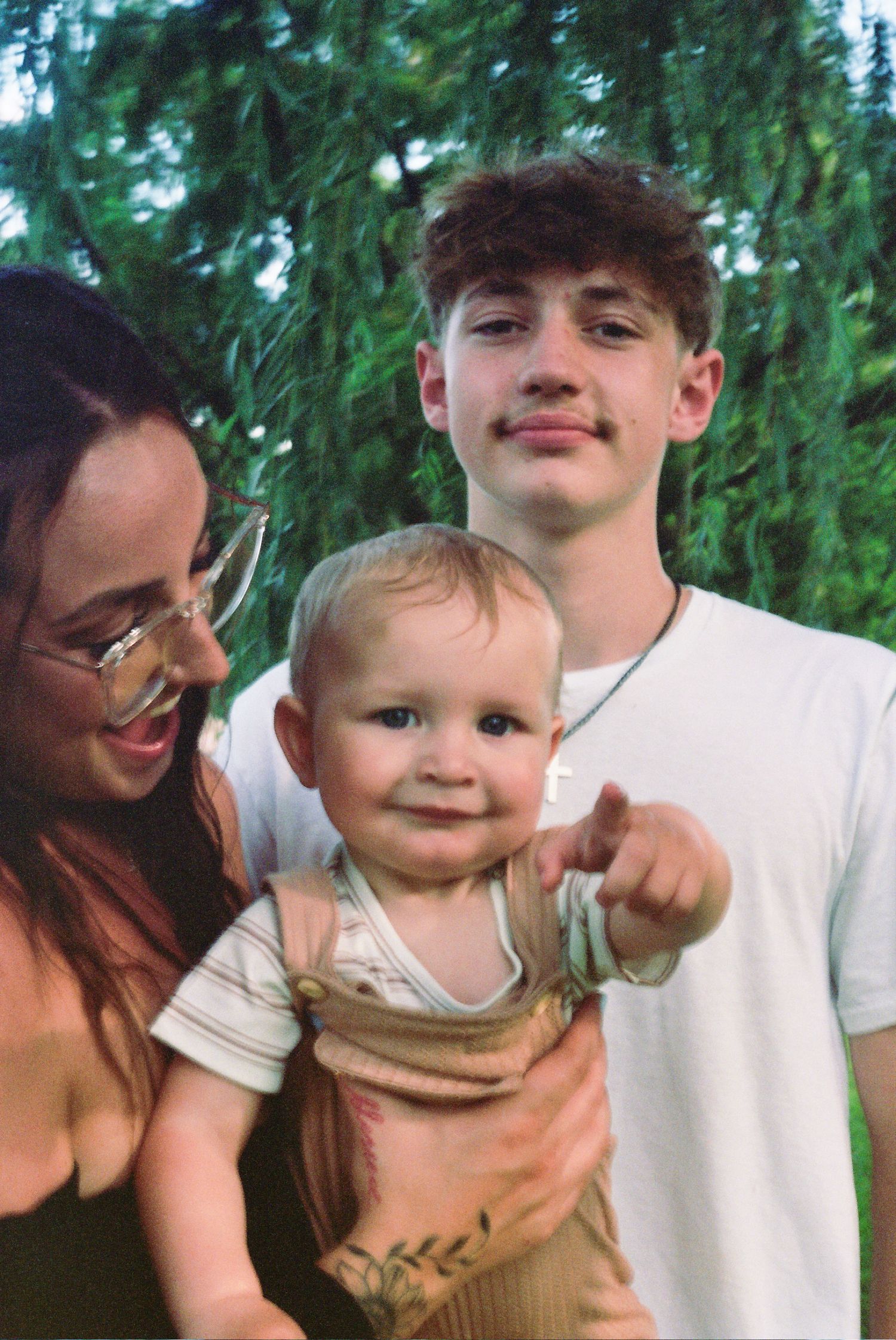 Three cropped photos show loving family moments outdoors with a baby against a green background of trees.