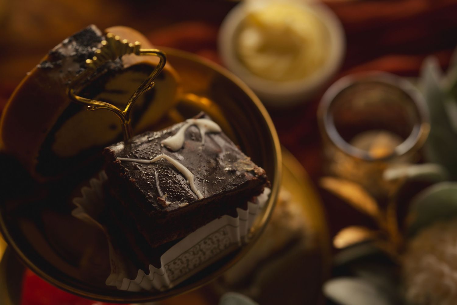 Close-up macro shot of dark chocolate candy in ornate packaging with blurred background.
