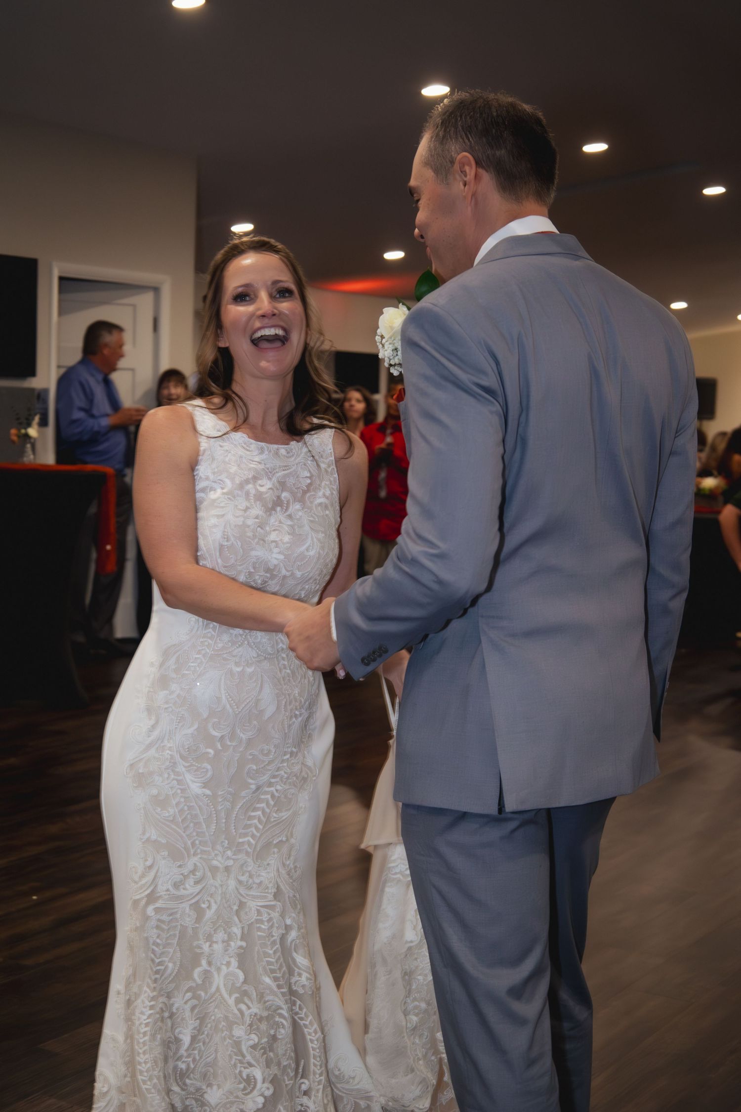Wedding couple sharing happy moment while dancing at reception venue.