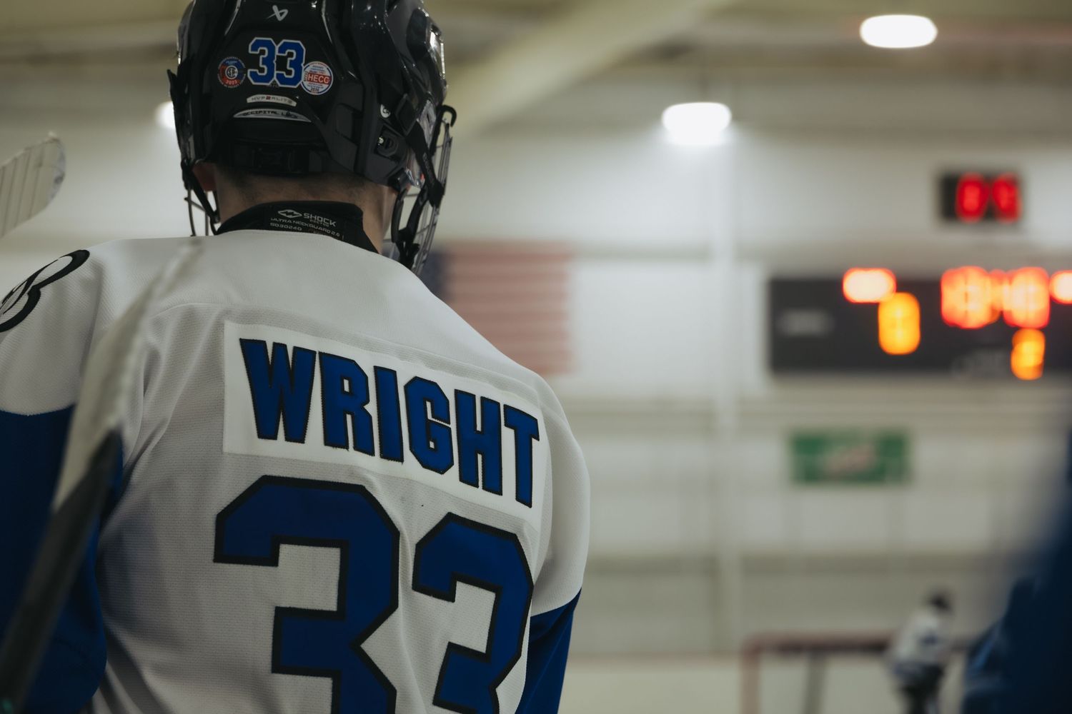 Hockey player wearing jersey number 32 with name 'Wright' visible from behind during indoor game.