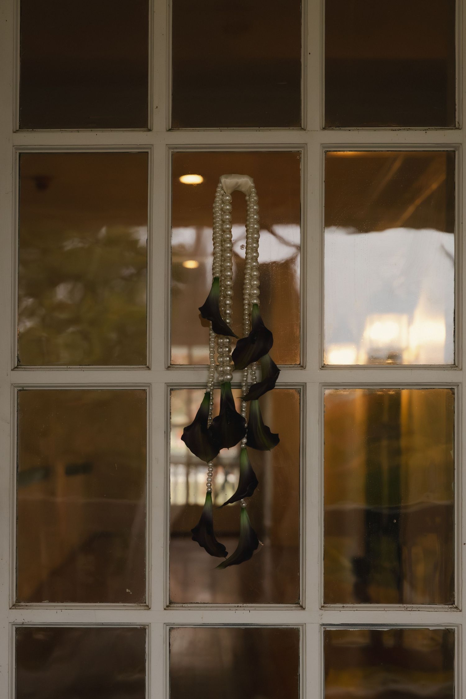 Decorative black metal sconces mounted on white window frames create an elegant exterior lighting arrangement.