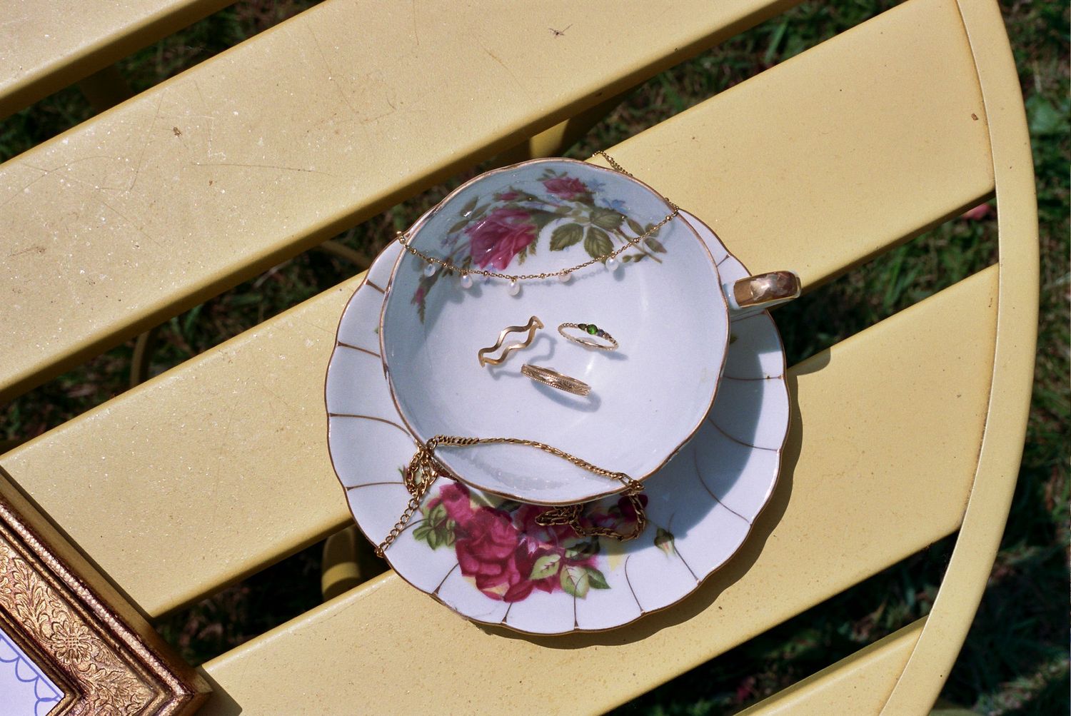 Delicate vintage-style decorative plates with floral patterns arranged in a row on wooden wall shelves.