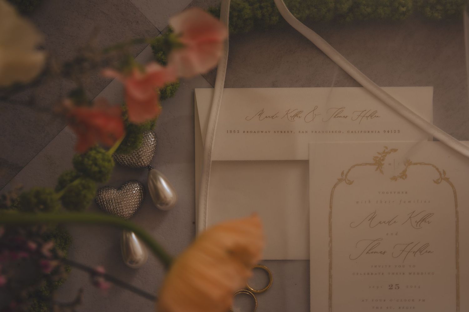 Wedding invitation and floral details captured in soft focus.