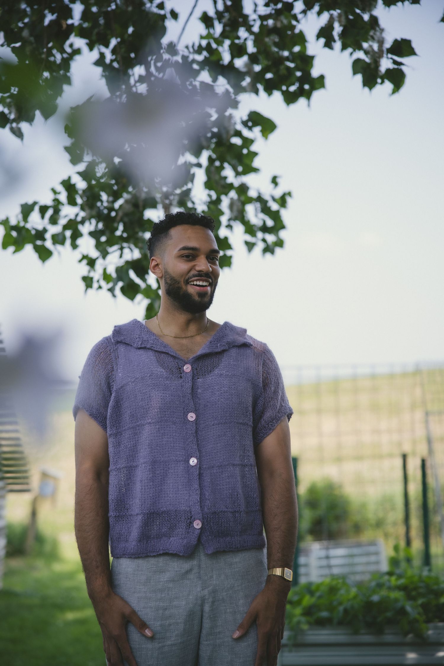 Five sequential photos show a person wearing a purple shirt and jeans standing outdoors in a garden setting.