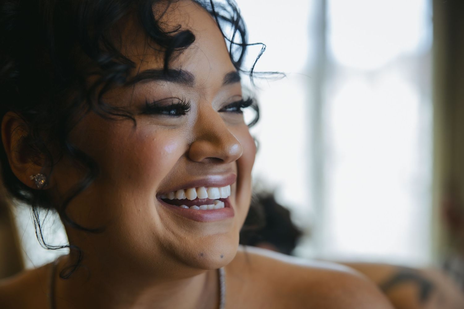 Happy person with curly hair and bright smile shown in a natural light collage of four closeup photos.