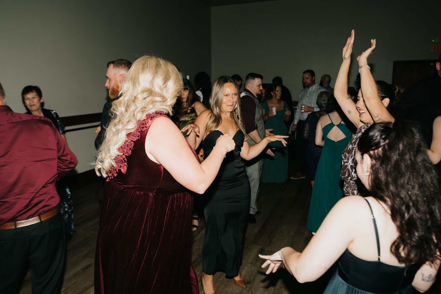 Guests dancing joyfully at an elegant evening wedding reception in formal attire.