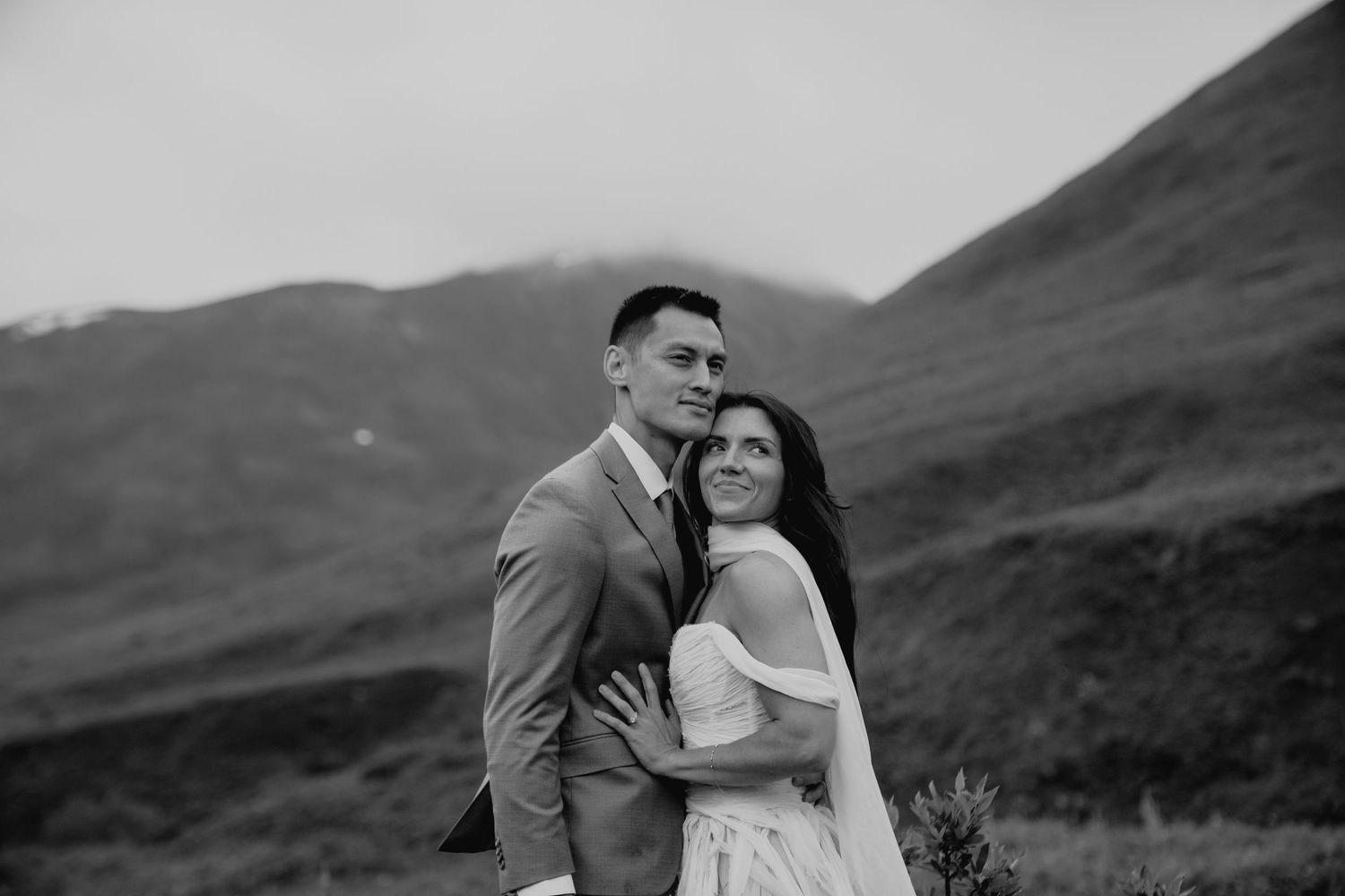 Romantic mountain elopement photos captured against rolling green hills in Alaska