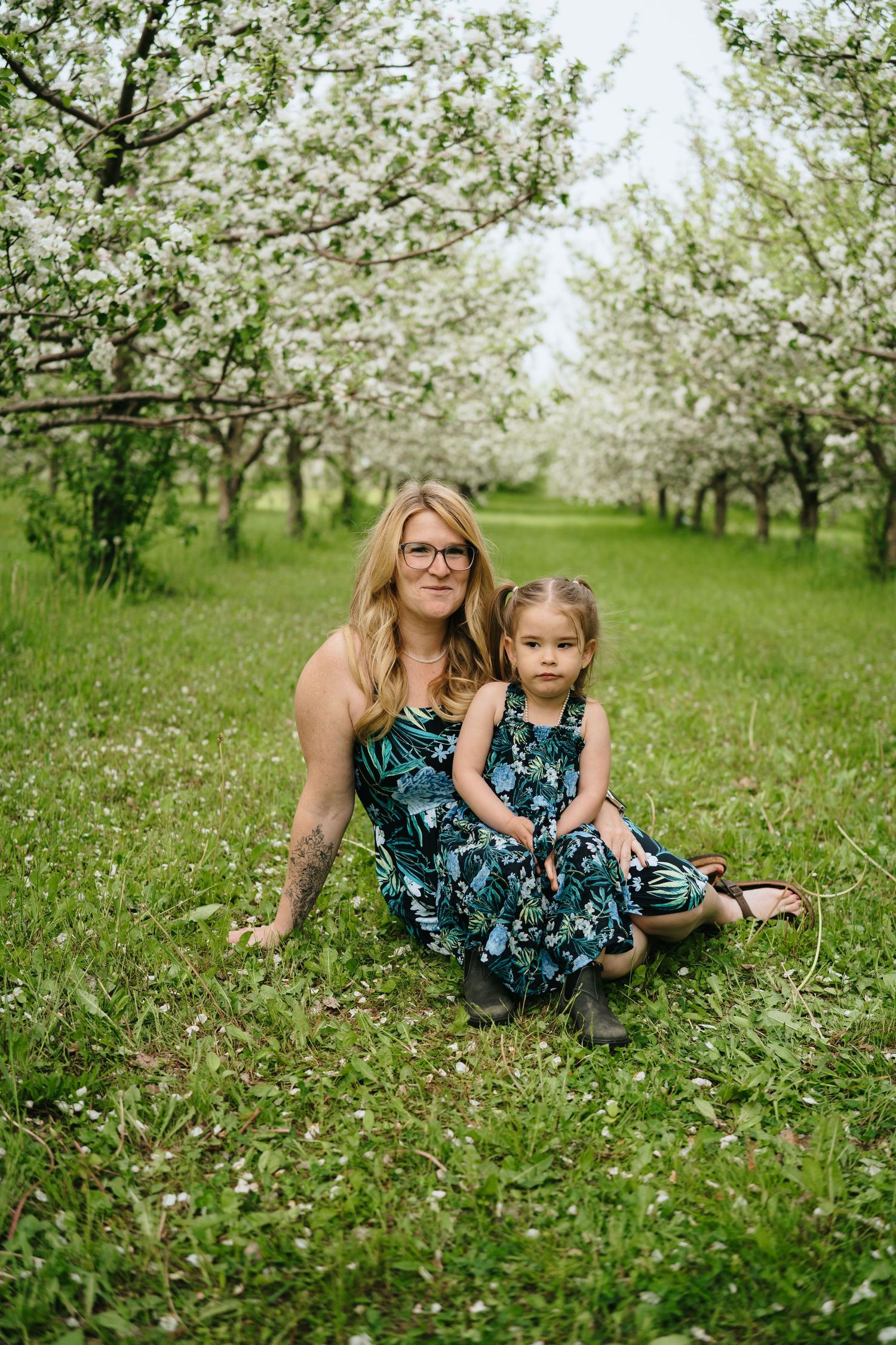 Matching floral dresses in a beautiful spring orchard setting.