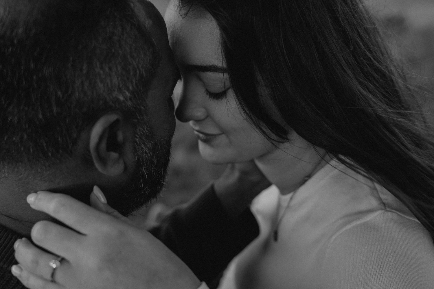 A romantic black and white close-up of a tender kiss.