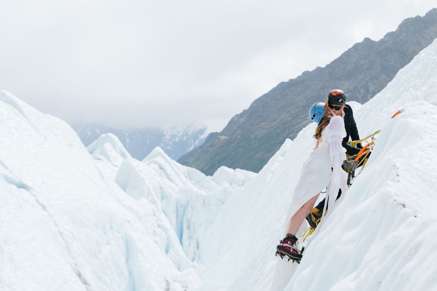 Wedding photo session on dramatic snow-covered mountain terrain in Alaska