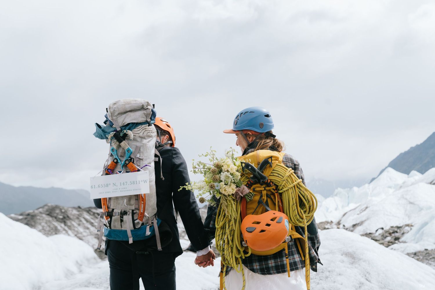 Adventure hikers with backpacks traversing a snowy glacier landscape in Alaska