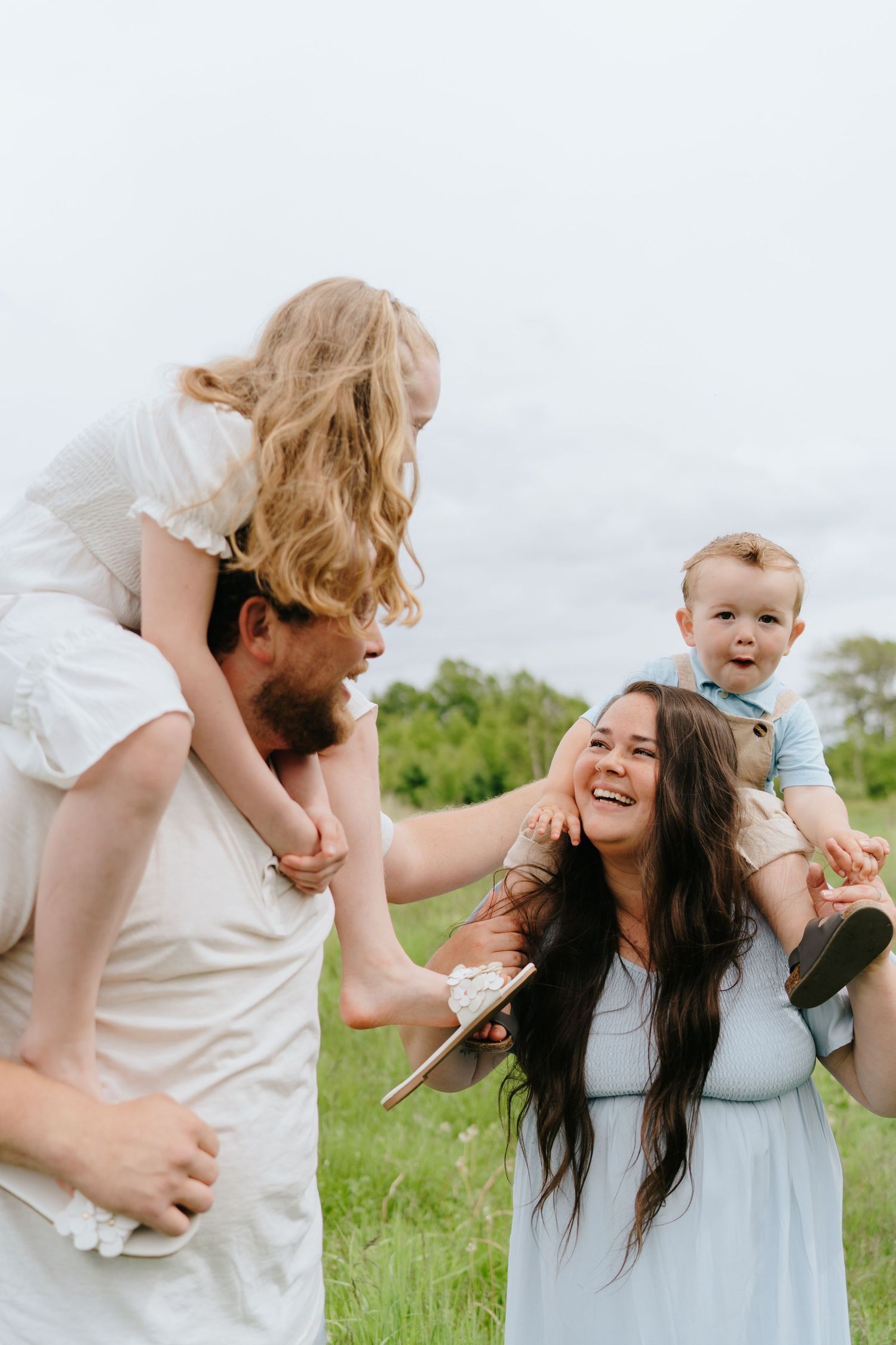 Playful family moments captured in a sunny meadow with wildflowers.