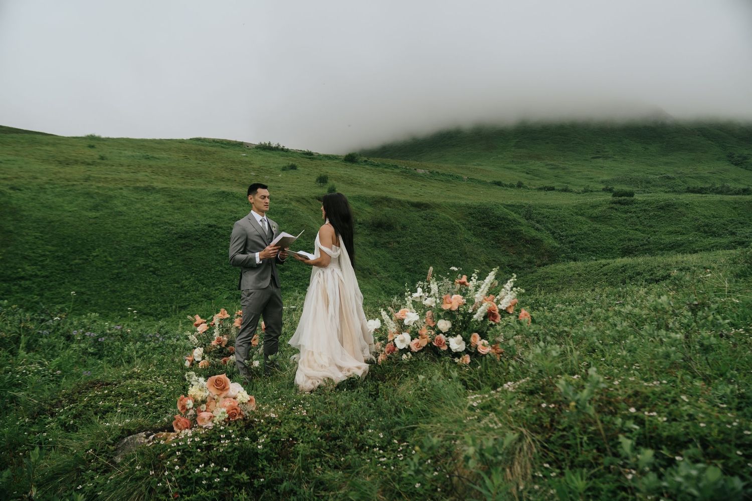Wedding photography session in a dramatic mountain landscape with flowing dress and florals in Hatcher Pass Alaska