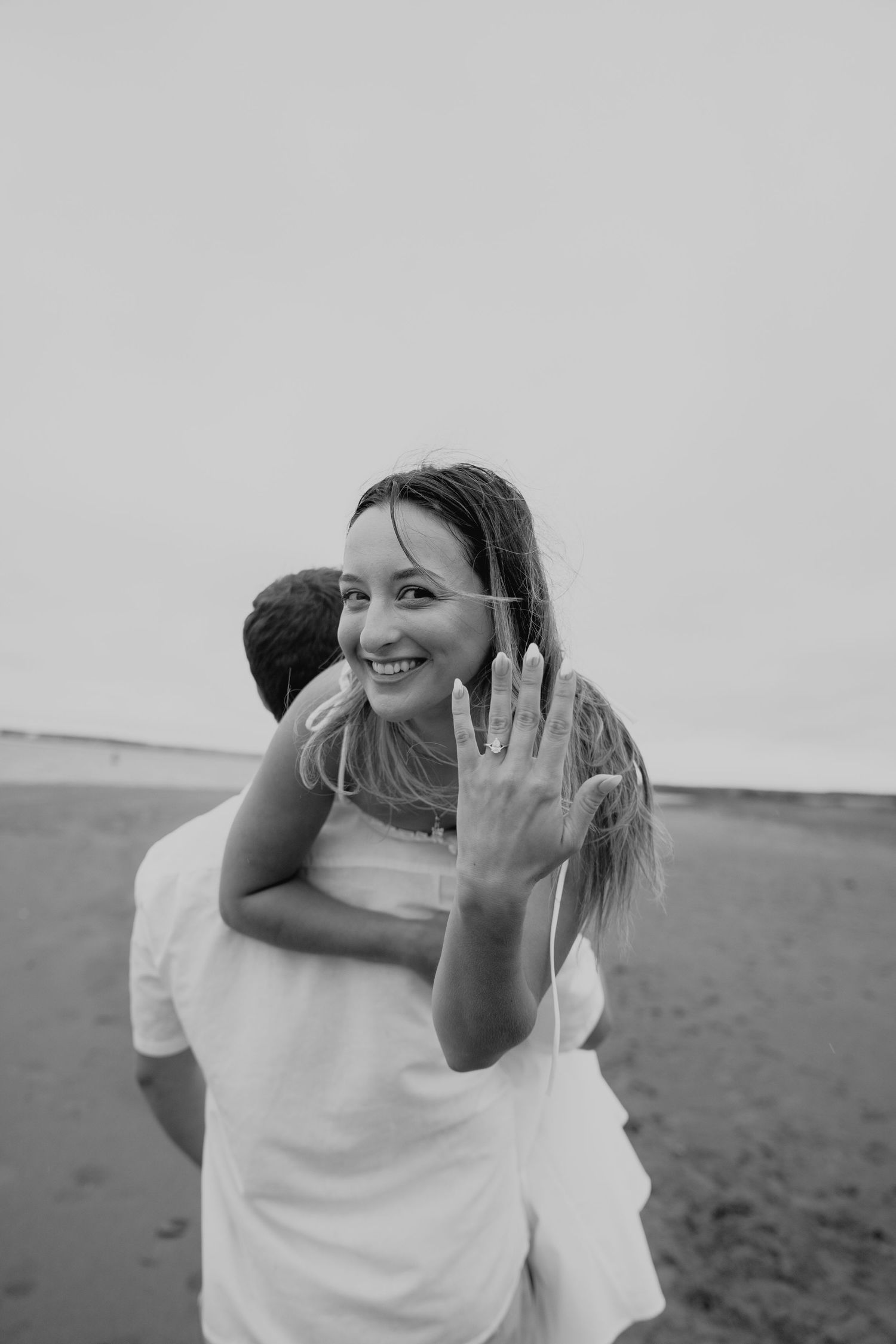 Black and white candid photos of a joyful couple sharing intimate moments outdoors.