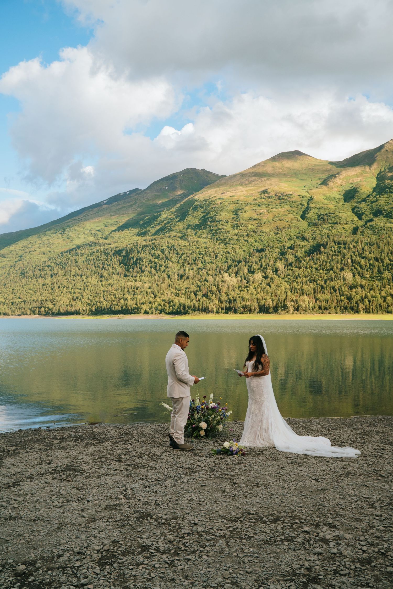 A scenic lakeside ceremony at Eklutna Lake, Alaska with mountain views and cloudy skies.
