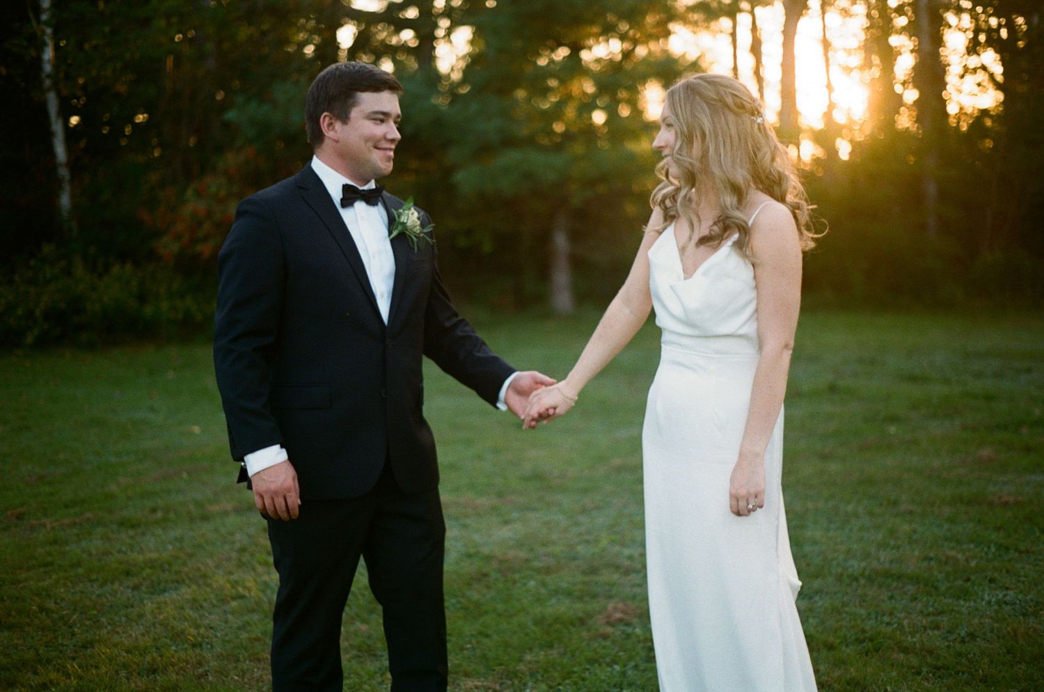 Playful dancing sequence on grass during golden hour wedding photoshoot.