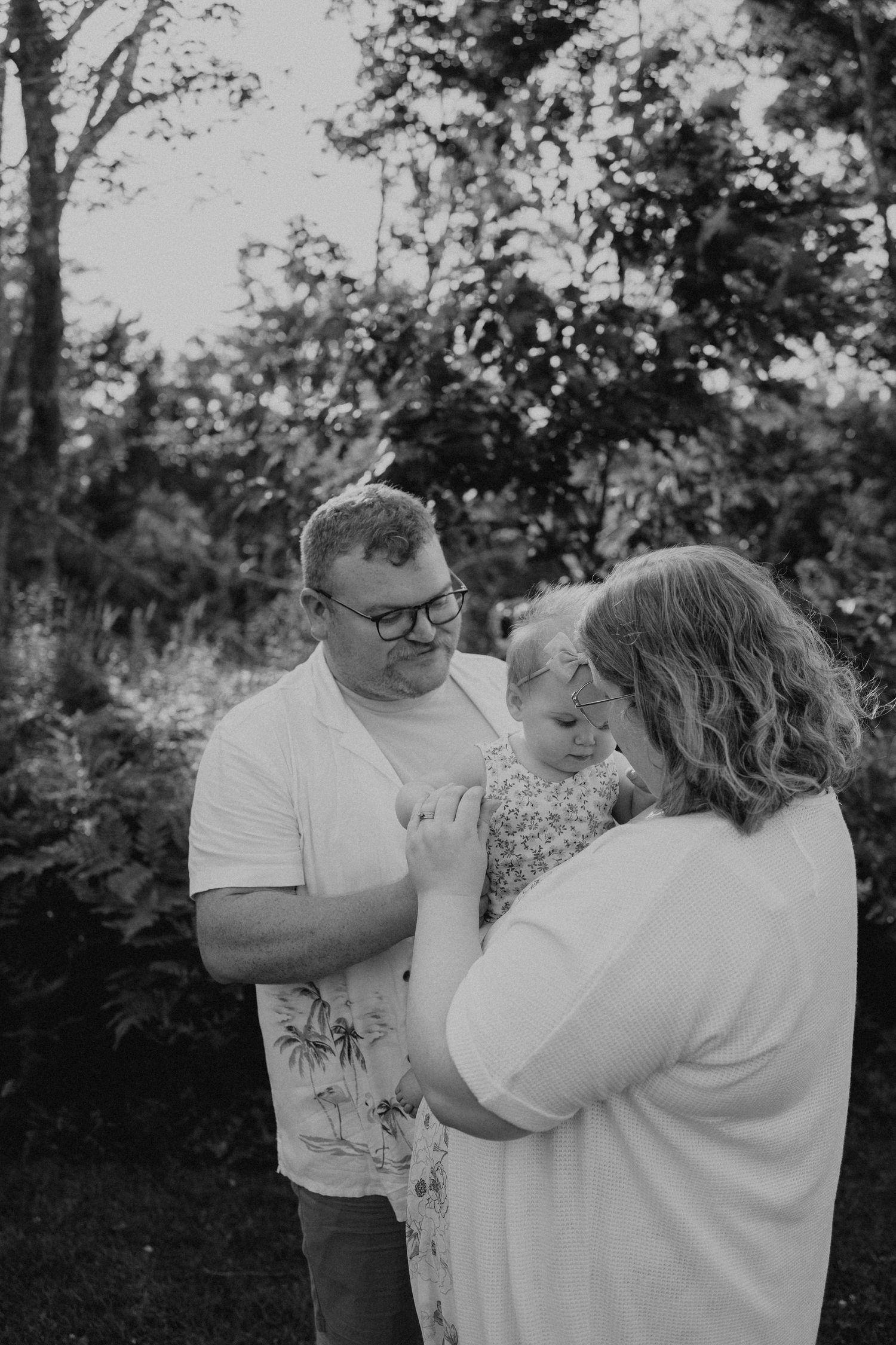 A heartwarming family moment captured in black and white outdoors.