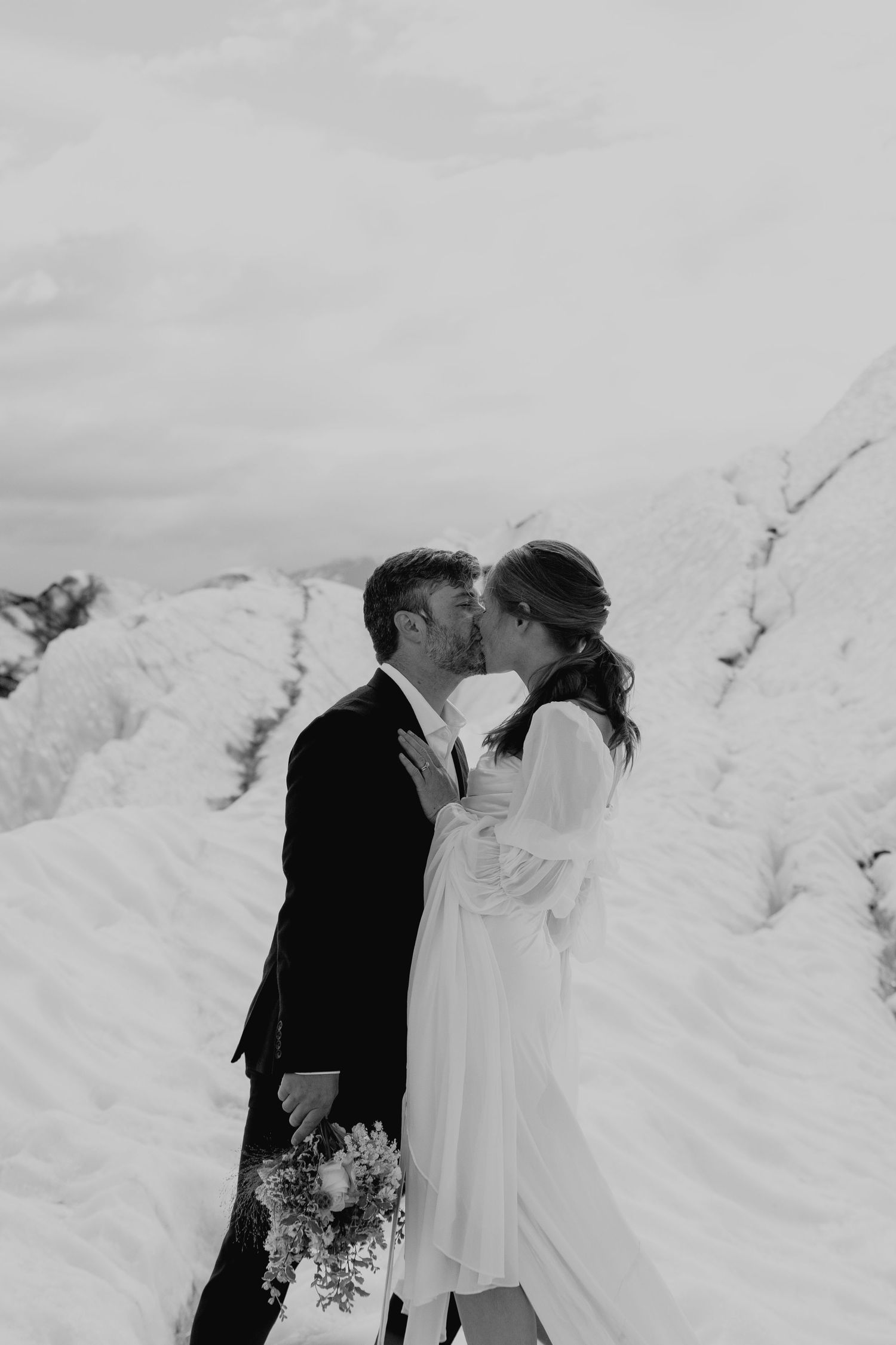 A romantic winter wedding photoshoot against a snowy white backdrop in Alaska
