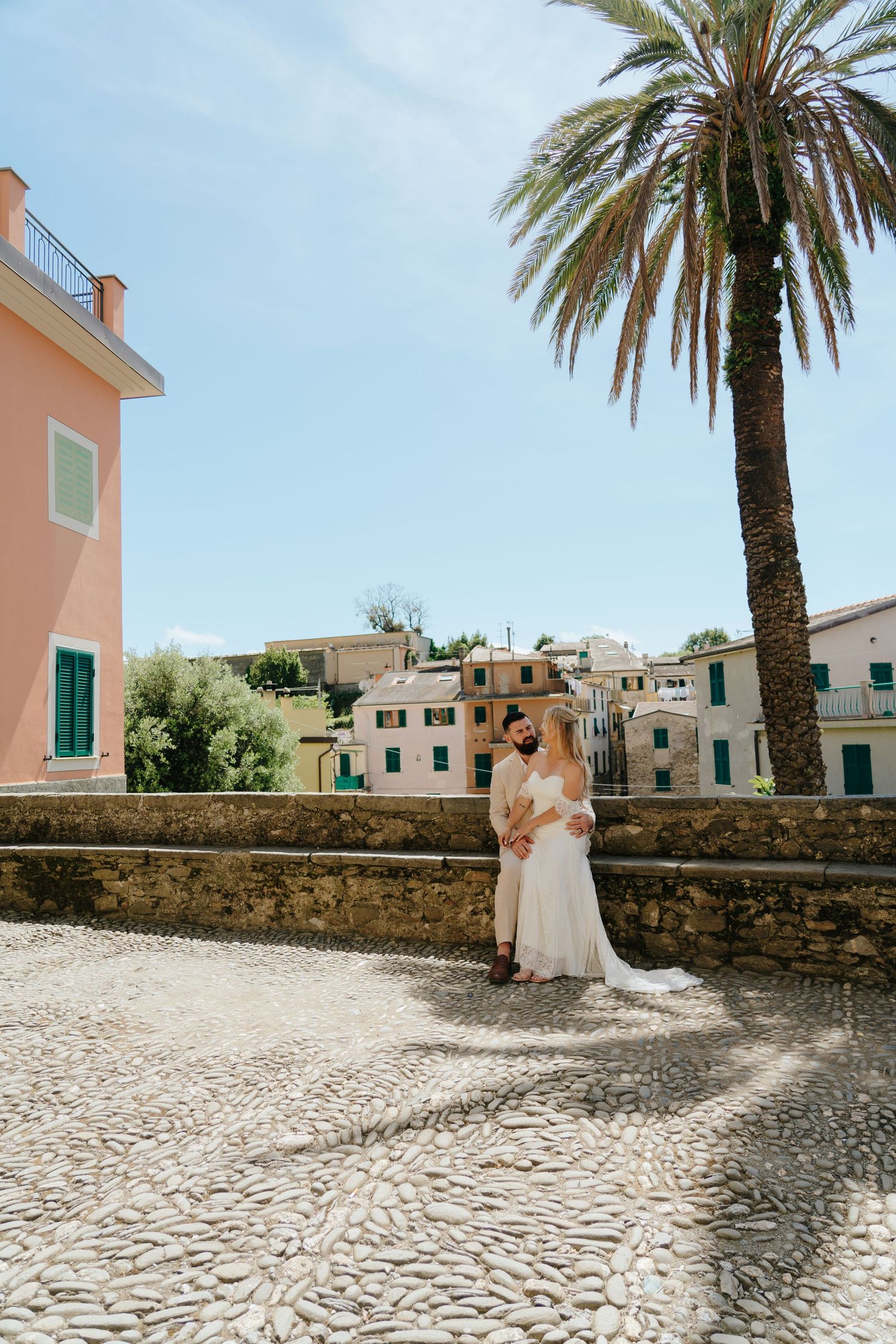 A series of four photos showing a sunny Mediterranean courtyard with palm trees and white stone buildings.