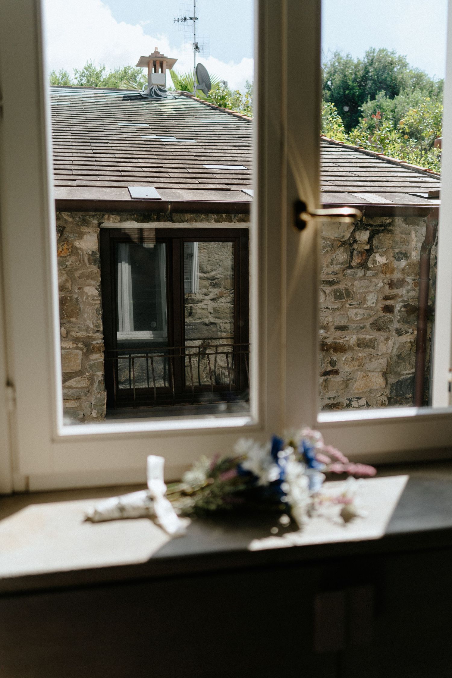 A series of windows in a rustic stone wall interior showing natural daylight streaming in.