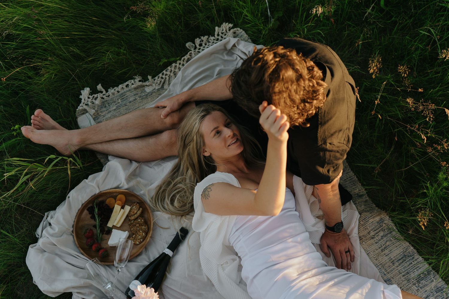 Artistic photo sequence of two people embracing in a golden sunlit meadow.