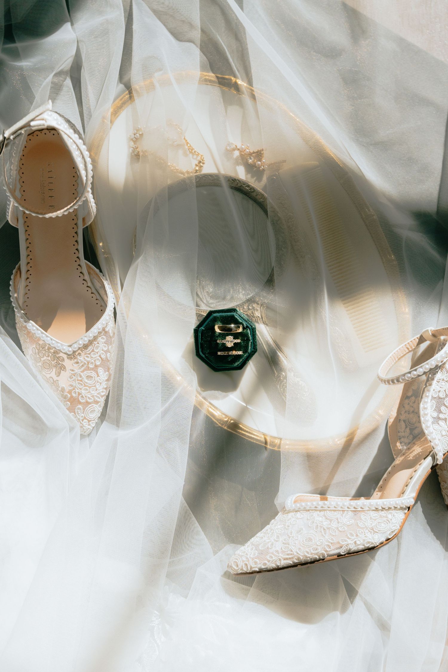 Elegant bridal shoes with pearl details arranged on white fabric.
