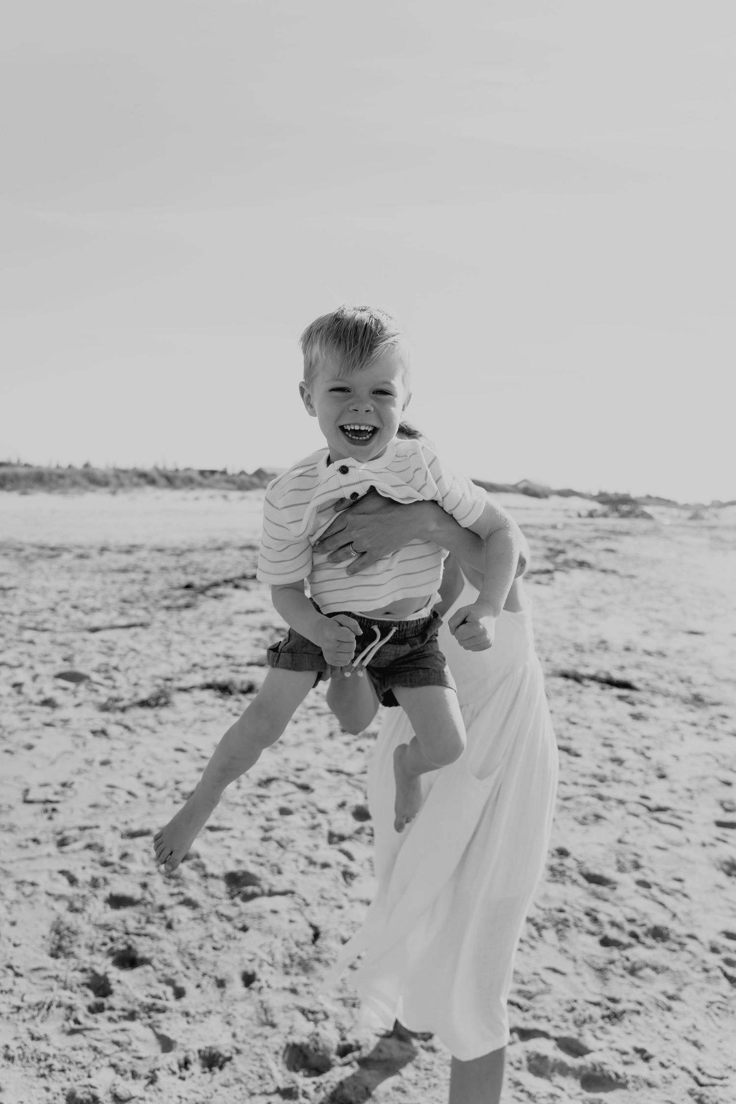 Black and white photos of playful moments on a sunny beach day.