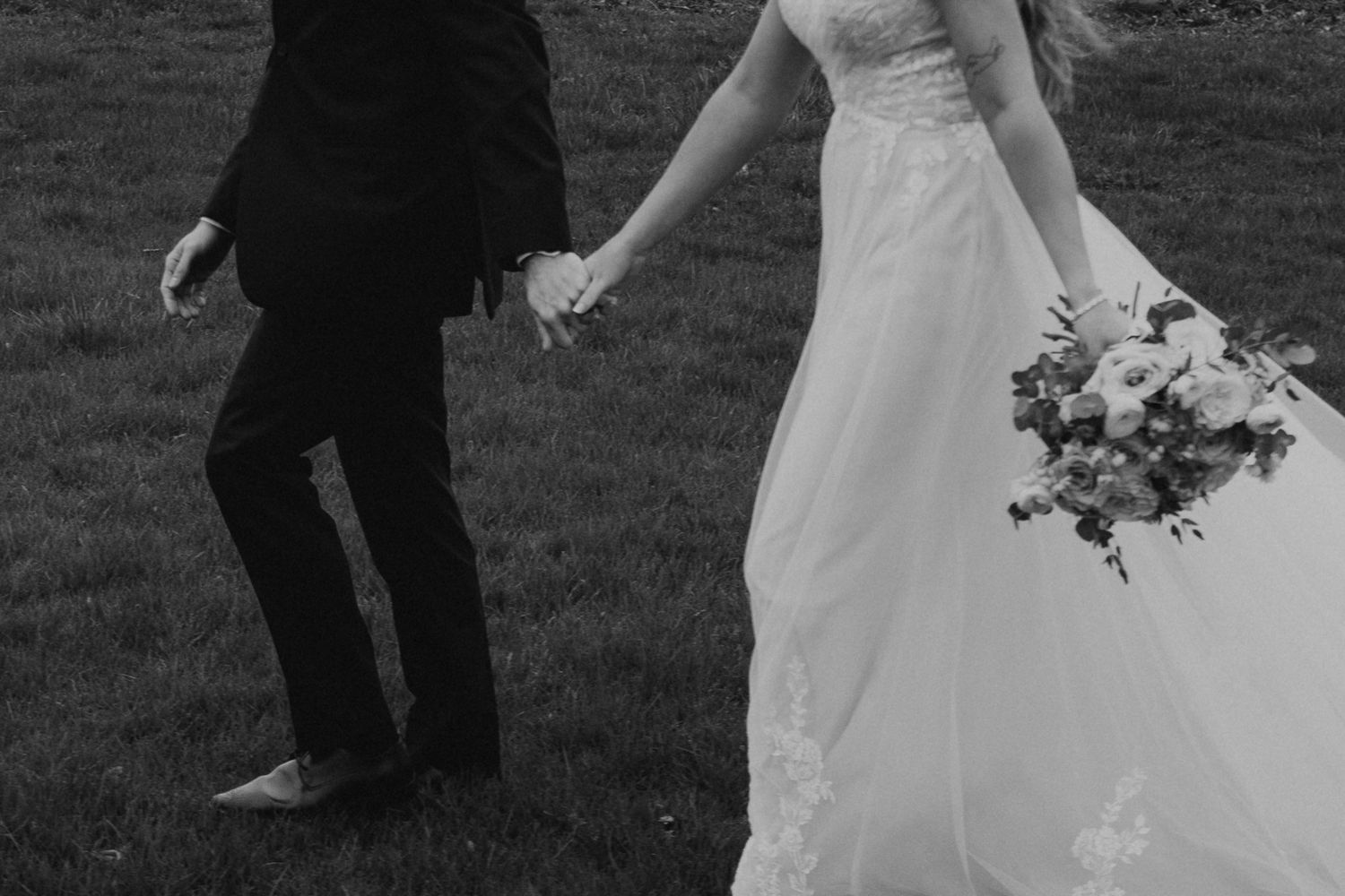 Black and white wedding photo showing dancing and movement on an outdoor dance floor.