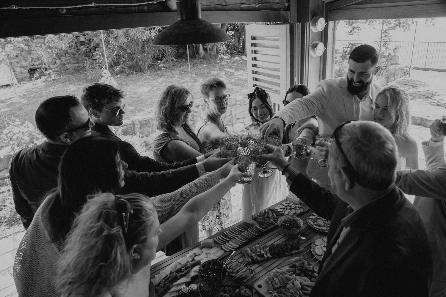 Black and white candid gathering of people in an intimate Italian indoor setting.