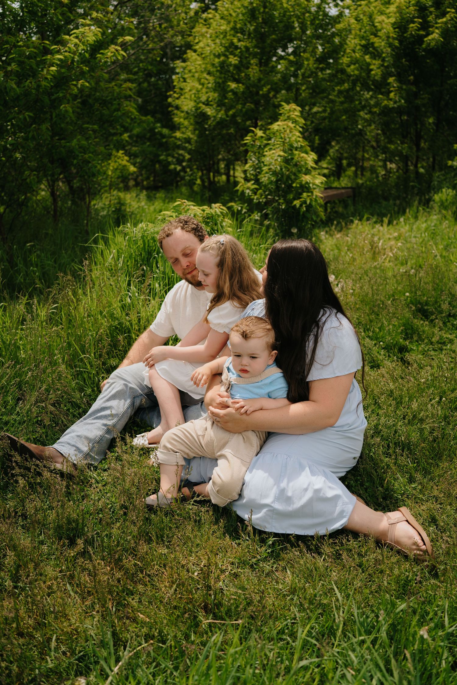 Intimate family portraits taken in a verdant summer field setting.