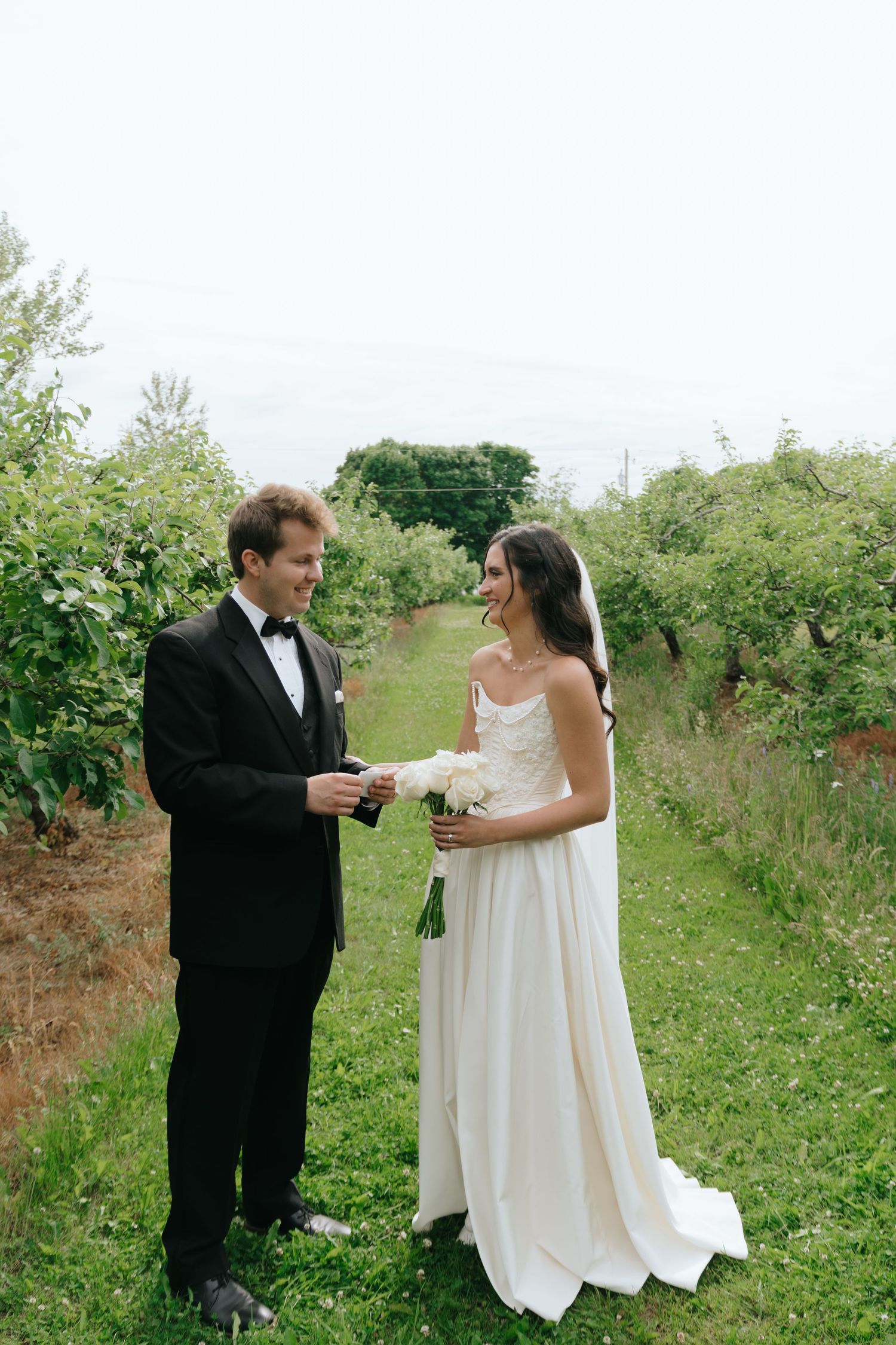 A couple shares an intimate moment in a garden path surrounded by greenery.