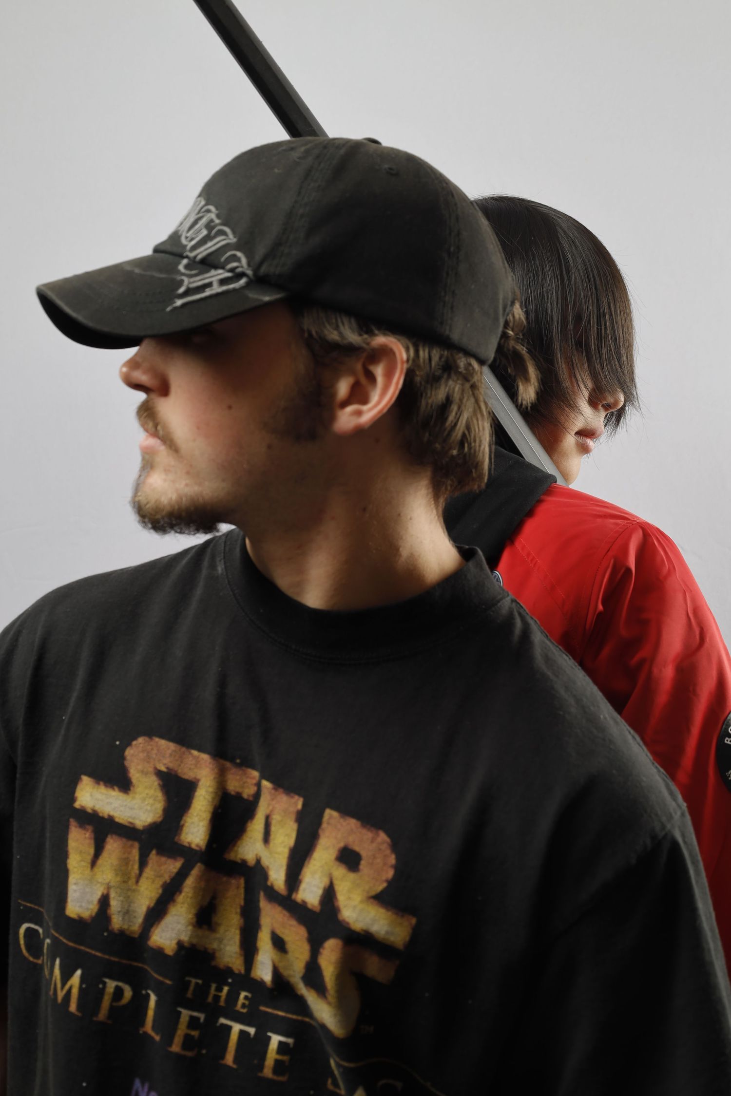 Side profile shot of two people wearing Star Wars merchandise and baseball caps.