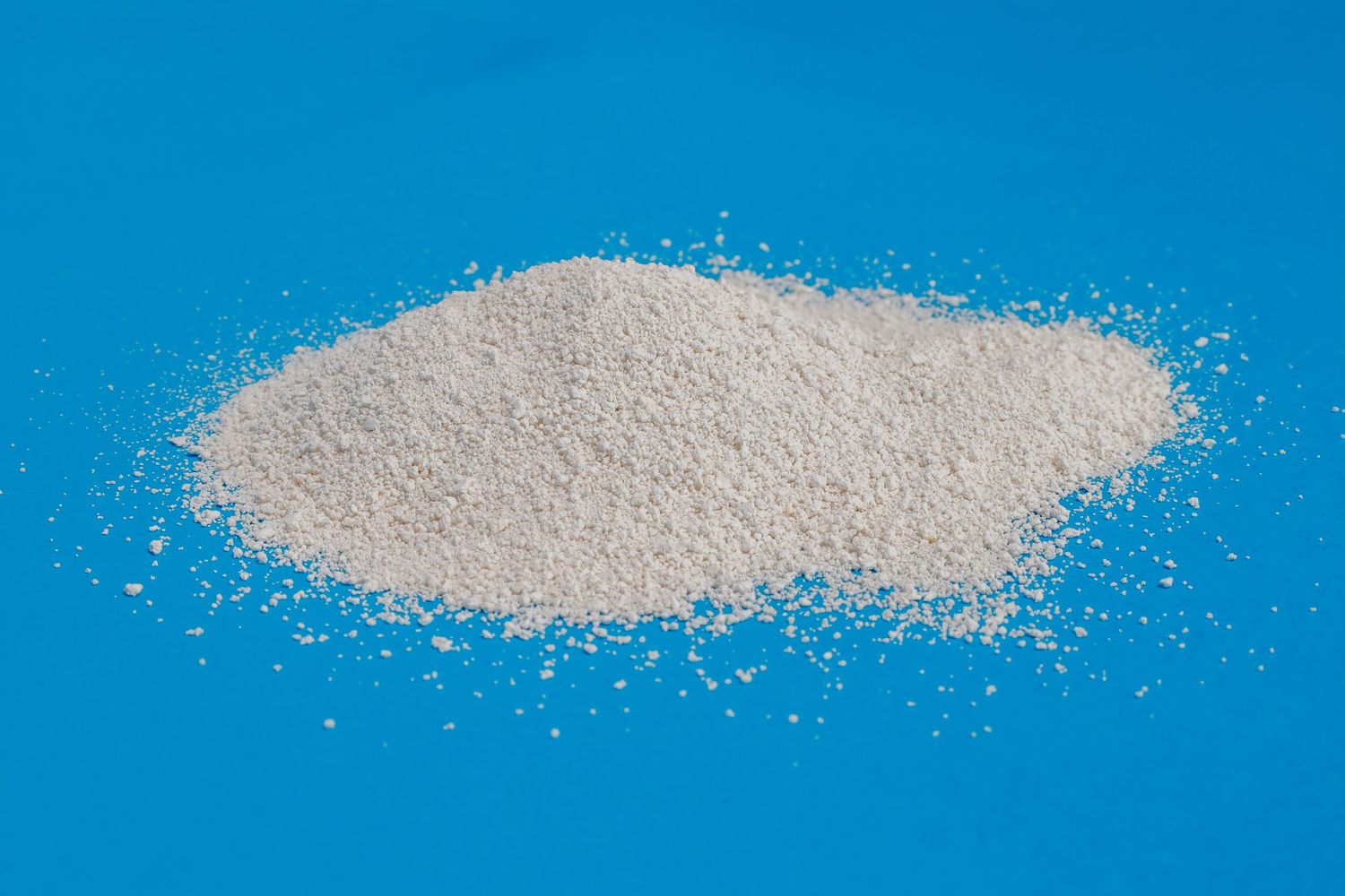 White powdery substance scattered on bright blue background.