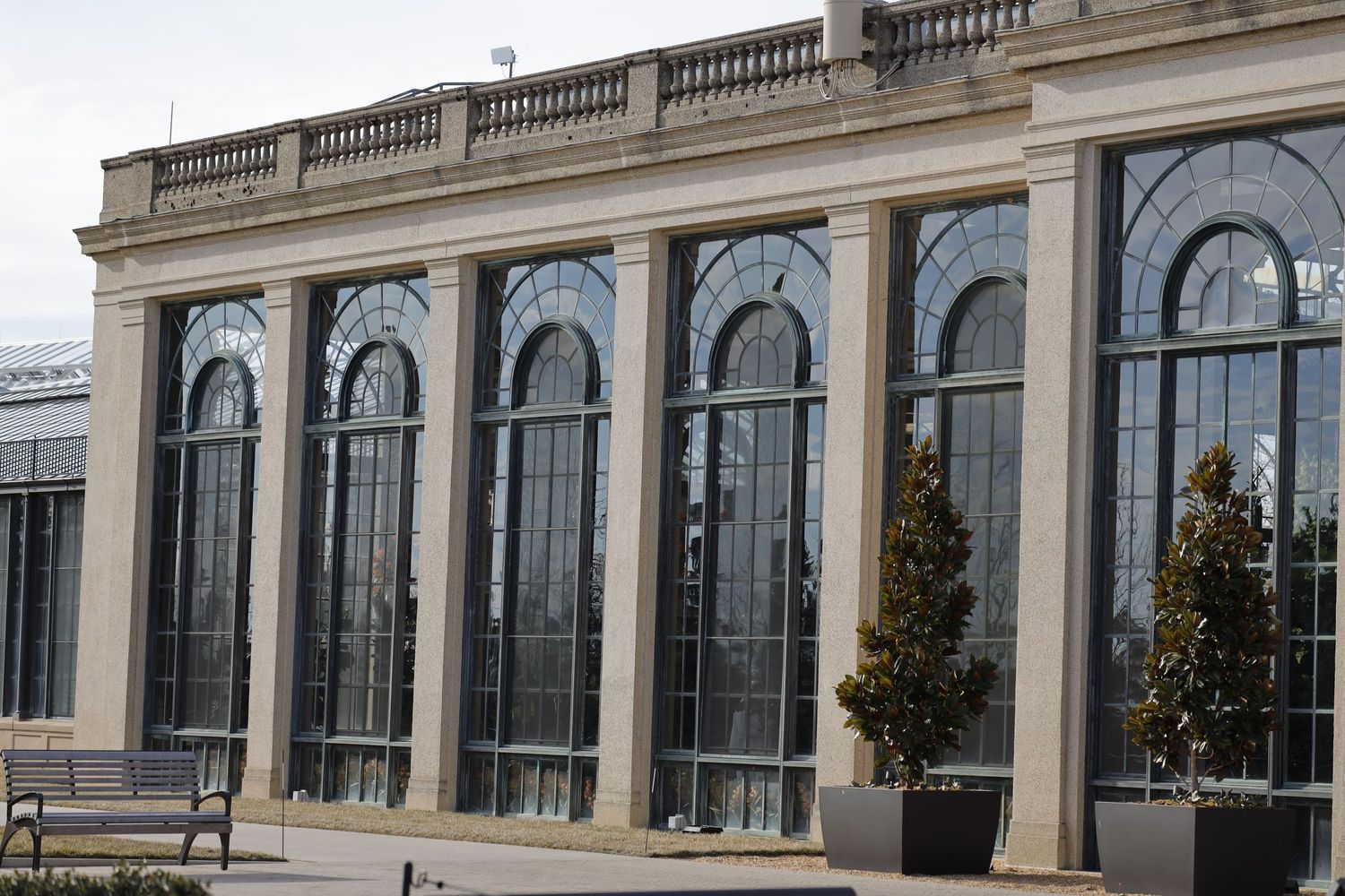 Classical building facade with ornate arched windows and stone balustrade.