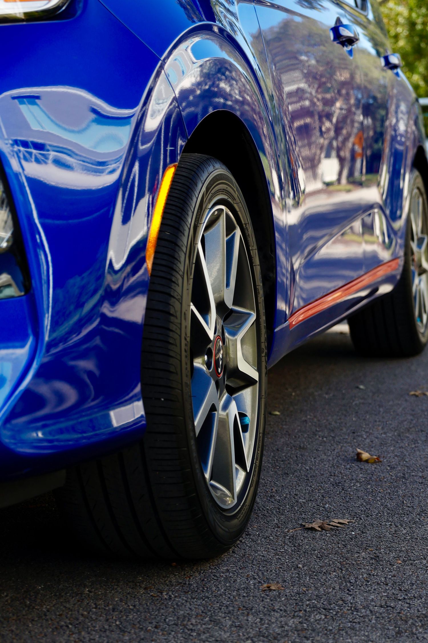 Close-up of blue Kia Soul's wheel and side panel showing sporty alloy rim design.