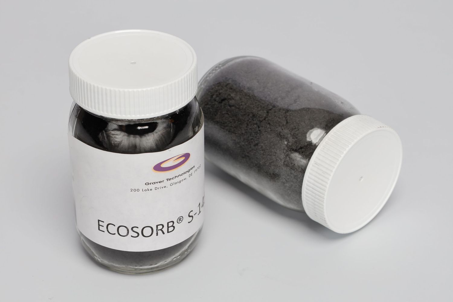 Two black plastic containers of Ecosorb powder with white screw-on lids against a gray background.