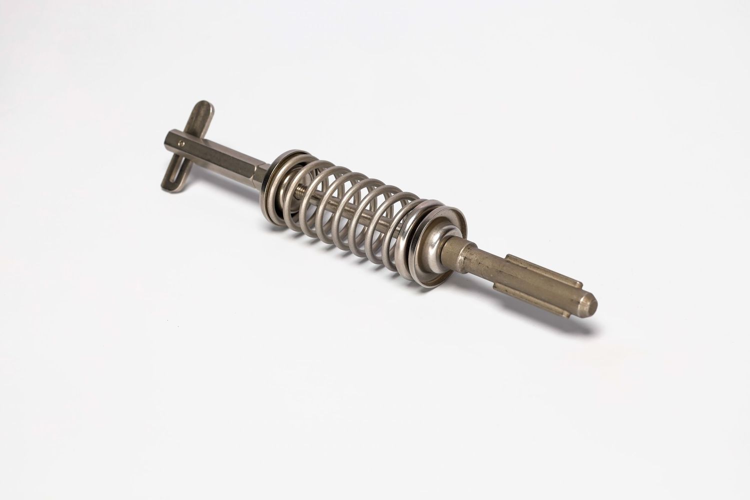 Vintage metal spring-loaded mechanical pin or plunger mechanism shown against white background.